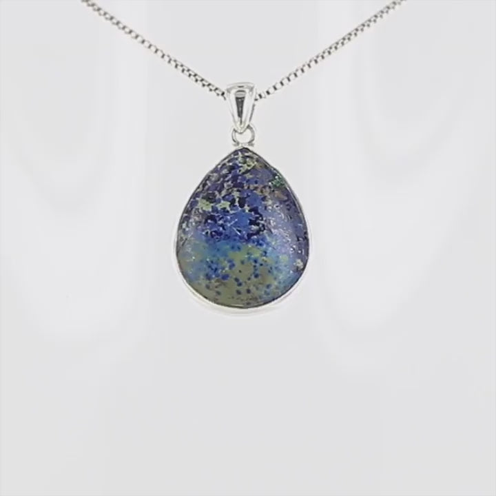 Pendentif artisanal en argent massif 925 serti d’une azurite de Morenci en forme de goutte, pierre naturelle aux nuances bleues, vertes. Le serti clos met en valeur cette pierre. Bijoux unique, éthique et durable présenté dans un coffret de notre marque, prêt à offrir. Livraison offerte, certificat d'authenticité, service client.