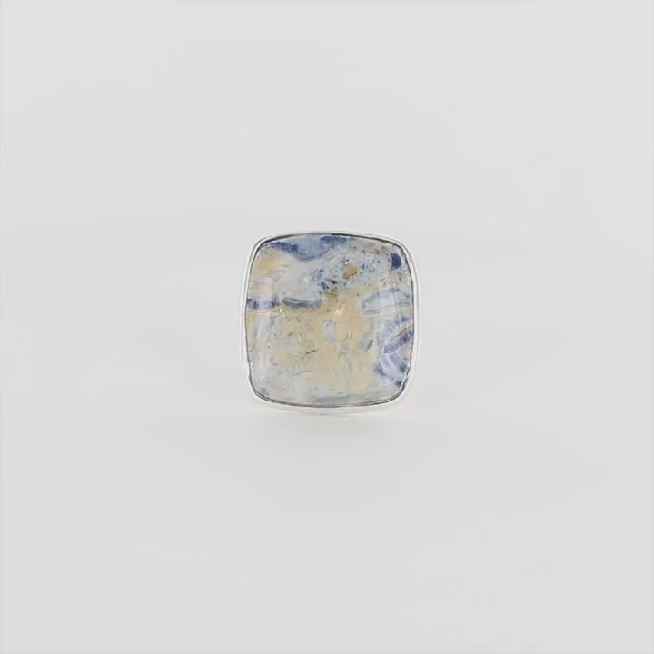 Bague carrée pour femme en argent massif sertie d'une scheelite bleue. Pierre naturelle de couleur bleu, beige creme et blanc de qualité opaque. Taille 60. Bijoux unique, éthique et durable présenté dans un coffret de notre marque, prêt à offrir. Livraison offerte, certificat d'authenticité, service client.