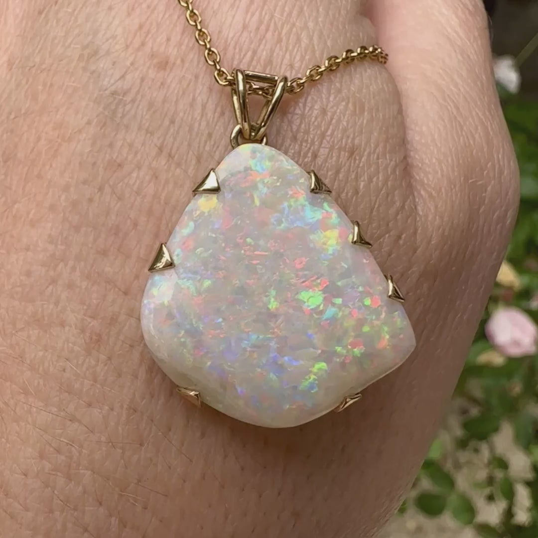 Pendentif pour femme en or jaune 18k serti d'une opale blanche de 17 carats aux feux multicolores. Pierre naturelle cabochon de forme irrégulière sertis de griffes. A noter: présence de roche mère de couleur crème au dos de la pierre. Bijoux unique, éthique et durable présenté dans un coffret de notre marque, prêt à offrir. Livraison offerte, certificat d'authenticité, service client