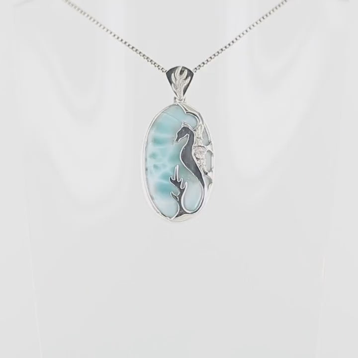 Pendentif artisanal en argent sterling 925 présentant un cabochon ovale de larimar bleu ciel aux nuances turquoise et blanches. Sur la pierre, un hippocampe en argent contraste élégamment avec les tons océaniques du larimar. L'ensemble évoque la sérénité des fonds marins caribéens. Bijoux unique, éthique et durable présenté dans un coffret de notre marque, prêt à offrir. Livraison offerte, certificat d'authenticité, service client.