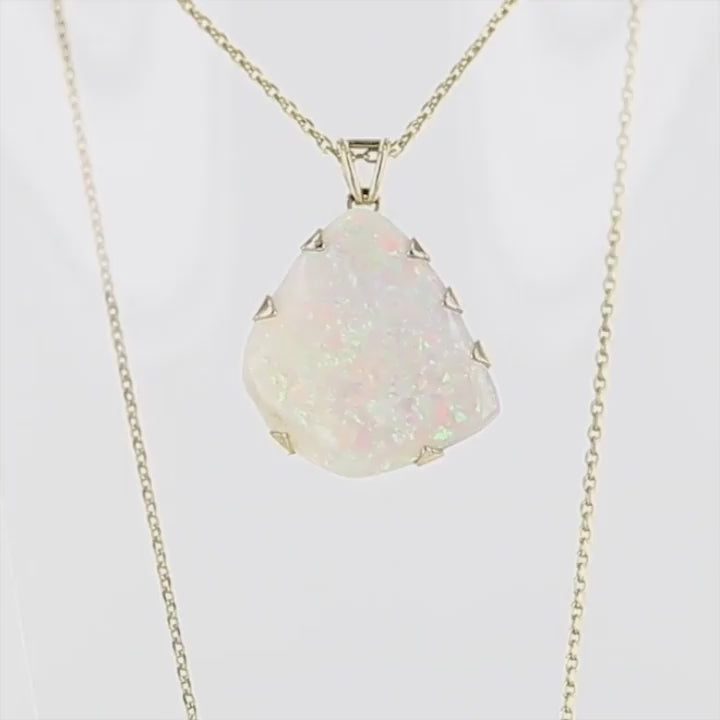 Pendentif pour femme en or jaune 18k serti d'une opale blanche de 17 carats aux feux multicolores. Pierre naturelle cabochon de forme irrégulière sertis de griffes. A noter: présence de roche mère de couleur crème au dos de la pierre. Bijoux unique, éthique et durable présenté dans un coffret de notre marque, prêt à offrir. Livraison offerte, certificat d'authenticité, service client