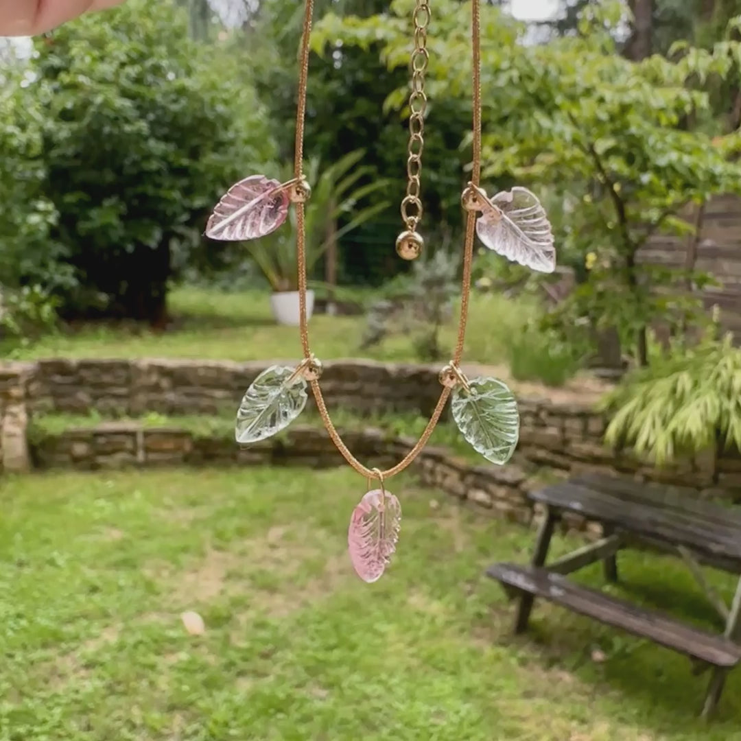 Collier pour femme orné de tourmalines roses et vertes sculptées à la main en 3 dimensions en forme de feuilles serties en or 18k. Les breloques sont montées sur un collier corde doré scintillant, les apprêts utilisé sont en Gold filled ( or laminé ). Longueur ajustable de 40 cm à 45 cm. Bijoux unique, éthique et durable présenté dans un coffret de notre marque, prêt à offrir. Livraison offerte, certificat d'authenticité, service client.