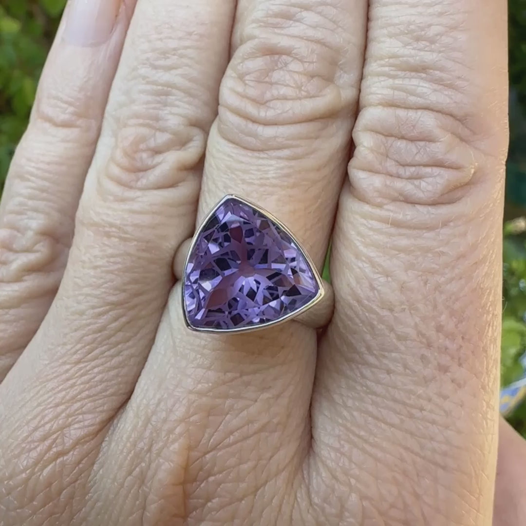 Bague cocktail pour femme en argent massif sertie d'une Améthyste. Pierre taillée trillion de qualité transparente, propre à l'oeil. Pierre naturelle de couleur violette clair gravée de motifs géométriques de fleur de vie. Tailles 58. Bijoux unique, éthique et durable présenté dans un coffret de notre marque, prêt à offrir. Livraison offerte, certificat d'authenticité, service client.