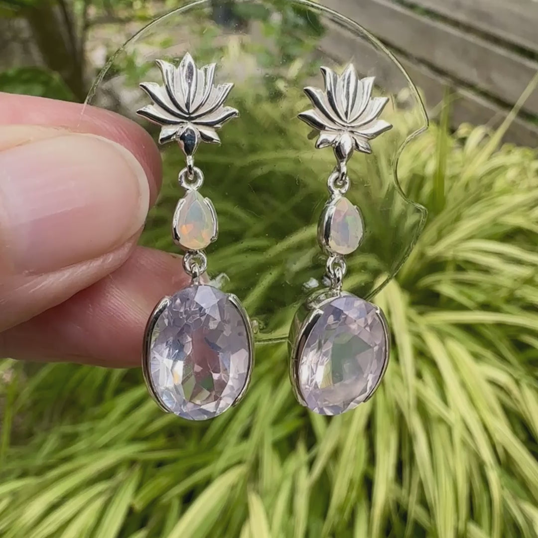Boucles d'oreilles Lotus pour femme en argent massif sertie de Quartz lavandes et d'opales d'Éthiopie. Pierres facettées de forme ovales et de gouttes de qualités transparentes, propre à l'oeil. Pierres naturelles de couleurs violettes pastel teintées de rose avec des reflets opalescents et multicolores pour les opales . Bijoux unique, éthique et durable présenté dans un coffret de notre marque, prêt à offrir. Livraison offerte, certificat d'authenticité, service client.