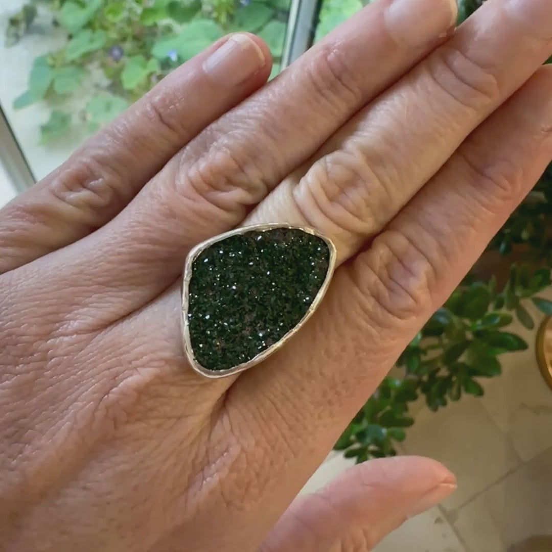 Bague en argent massif serti d'un grenat Uvarovite brute. Pierre naturelle recouverte de cristaux scintillants de couleur verte. Bague réalisée en taille 55. Bijoux unique, éthique et durable présenté dans un coffret de notre marque, prêt à offrir. Livraison offerte, certificat d'authenticité, service client.