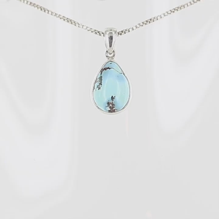 Élégant pendentif en forme de goutte présentant une turquoise Golden Hill d'un bleu ciel lumineux, parcourue de délicates veines minérales brunes caractéristiques. La pierre naturelle est sublimée par une fine monture en argent massif 925 qui épouse parfaitement ses contours. Cette création artisanale associe la sérénité du bleu turquoise à la pureté de l'argent, évoquant un fragment de ciel d'été. Un bijou intemporel aux les nuances naturelles.Livraison offerte, certificat d'authenticité, service client.