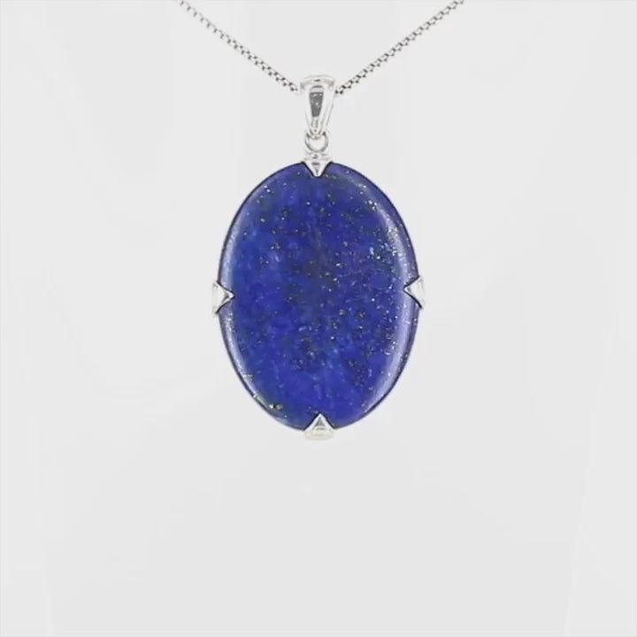 Pendentif en lapis-lazuli bleu profond avec inclusions dorées, serti de quatre griffes en argent massif 925. Le bijou, présente une pierre naturelle polie de forme ovale, montée sur une bélière sobre. Un bijou artisanal unique mettant en valeur la beauté minérale brute et élégante du lapis-lazuli. Bijoux unique, éthique et durable présenté dans un coffret de notre marque, prêt à offrir. Livraison offerte, certificat d'authenticité, service client.