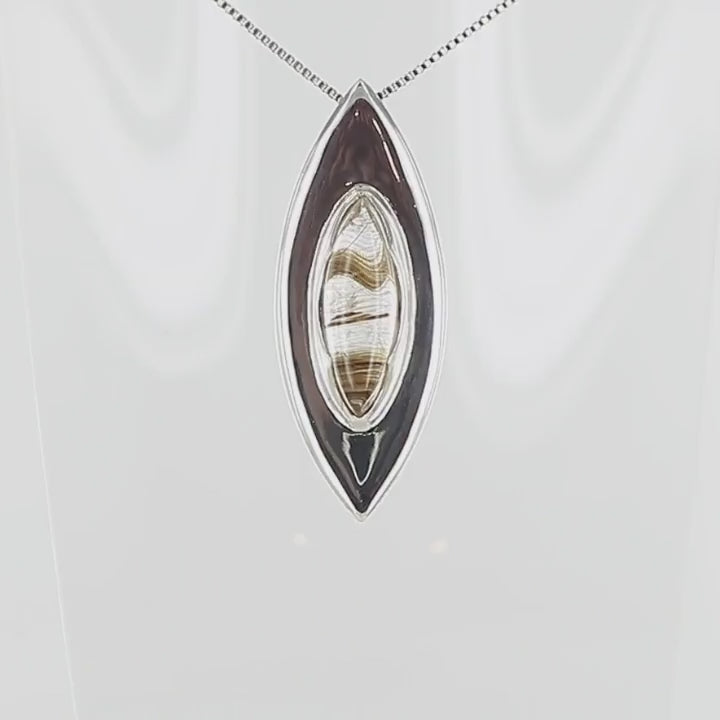 Pendentif en argent massif en forme d'amande, orné d'un quartz rutile doré naturel à inclusions filamenteuses, serti clos au centre d'une monture biseautée au design contemporain. Bijoux unique, éthique et durable présenté dans un coffret de notre marque, prêt à offrir. Livraison offerte, certificat d'authenticité, service client.