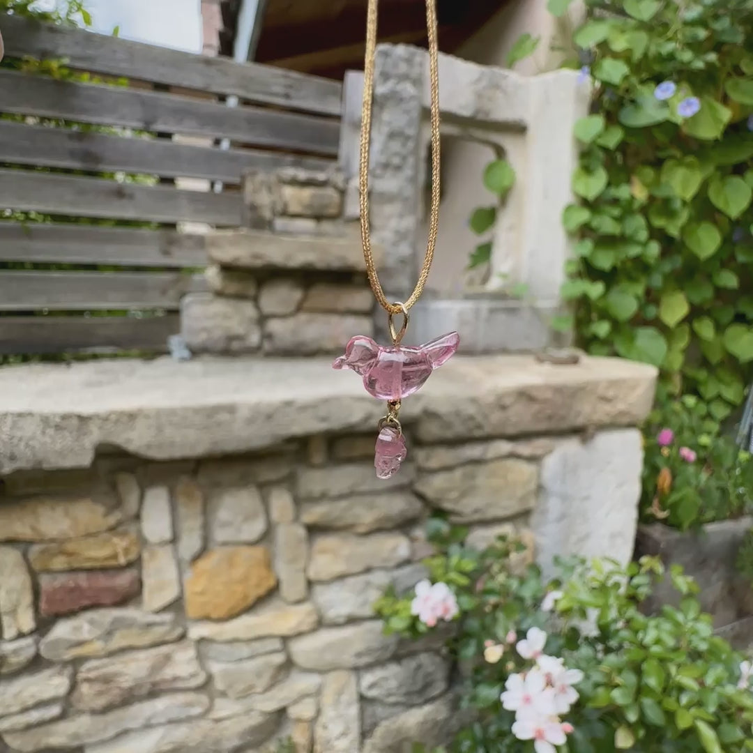 Collier pour femme orné d'une tourmaline rose sculptée à la main en 3 dimensions en forme d'oiseau et de feuille, serties en or 18k. Le pendentif est monté sur un collier corde doré scintillant, les apprêts utilisé sont en Gold filled ( or laminé ). Longueur ajustable de 40 cm à 45 cm. Bijoux unique, éthique et durable présenté dans un coffret de notre marque, prêt à offrir. Livraison offerte, certificat d'authenticité, service client.