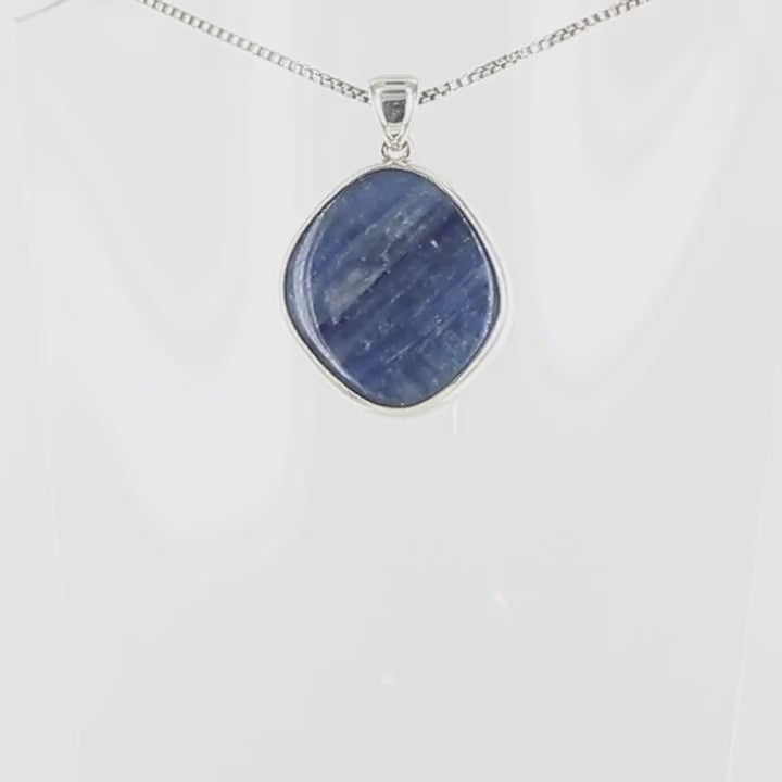pendentif pour femme en argent massif serti d'une Cyanite ou kyanite de couleur bleu" jean " avec de jolie nuance et un effet nacré. Pierre de forme libre taillé en cabochon. pierre translucide. Bijoux unique, éthique et durable présenté dans un coffret de notre marque, prêt à offrir. Livraison offerte, certificat d'authenticité, service client.