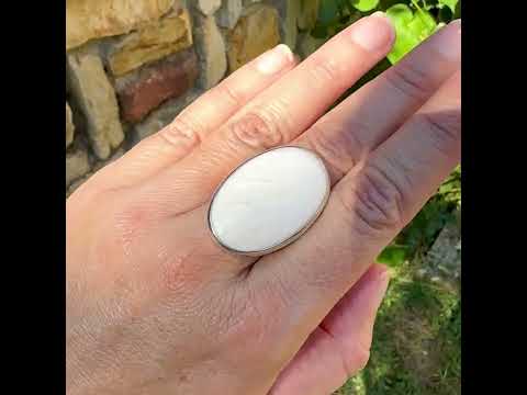 Bague pour femme en argent massif sertie d'un cabochon de scolecite de couleur blanc pur. Pierre naturelle de qualité opaque taillée en ovale. Bague unique réalisée en taille 58 par Orcha jewelry
