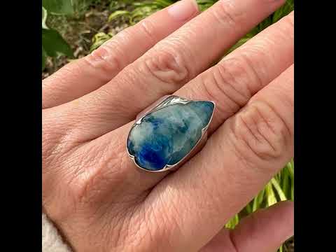 Bague pour femme en argent massif sertie d'un cabochon d'afghane de couleur bleu et bleu gris vert. Pierre taillée en forme de goutte de qualité opaque à inclusions (petites fissures) en surface, fréquente et admise sur ce type de pierre. Bijou unique réalisée en taille 58 par Orchajewelry