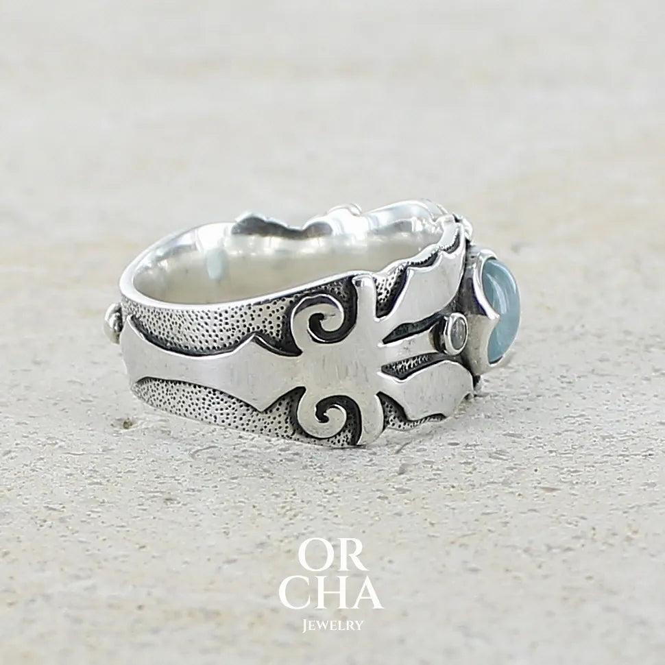 profil droit d'une Bague anneau pour homme en argent massif d'inspiration celtique, médiévale. Bague sertie d'un cabochon d'aigue-marine de couleur bleu gris. Pierre translucide propre à l'oeil. Bijou unique réalisé en taille 58.