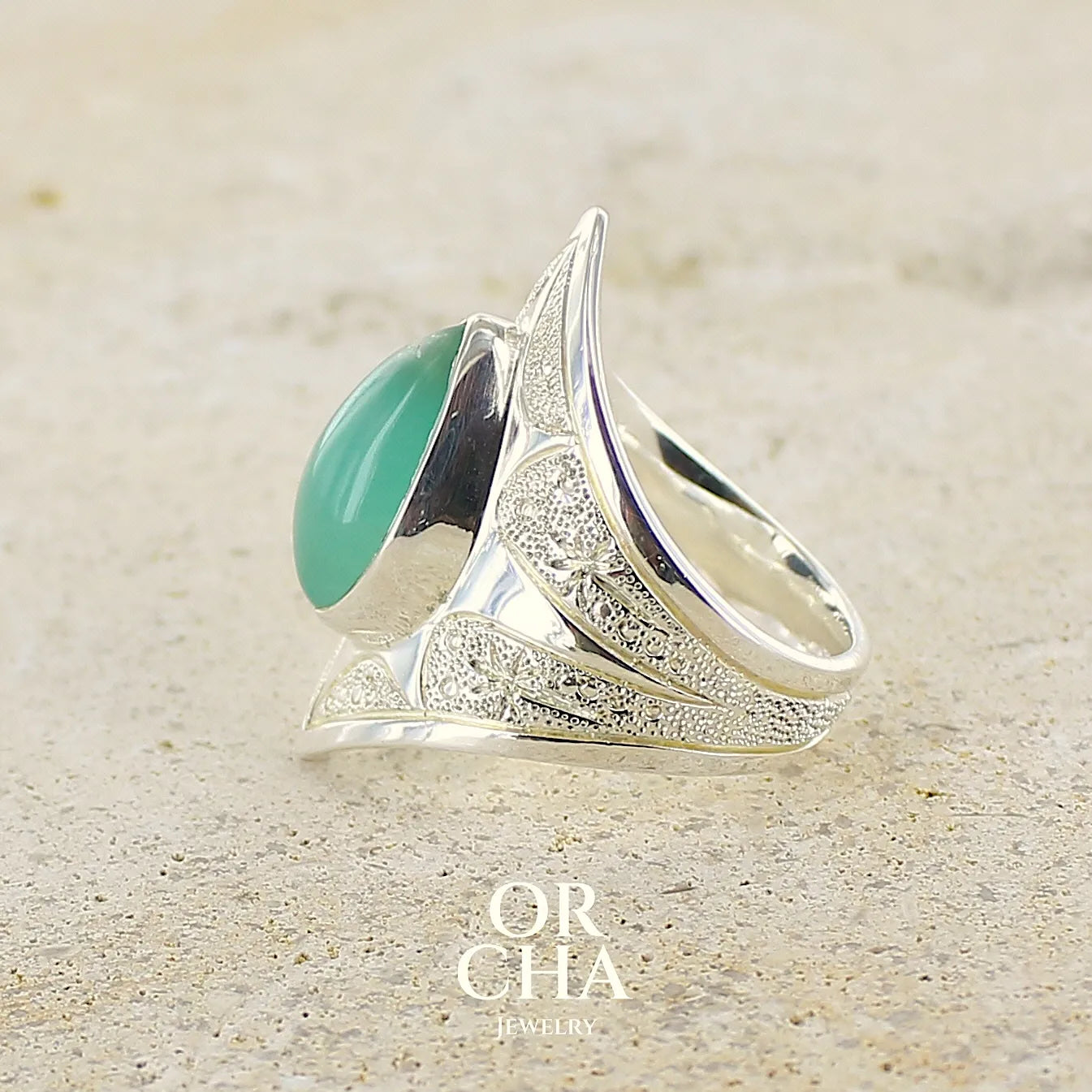 profil d'une grande Bague marquise pour femme en argent massif, sertie d'un cabochon de calcédoine bleue verte. Pierre taillée de en forme de goutte. Pierre translucide. bijou unique réalisée en taille 54 par Orcha Jewelry