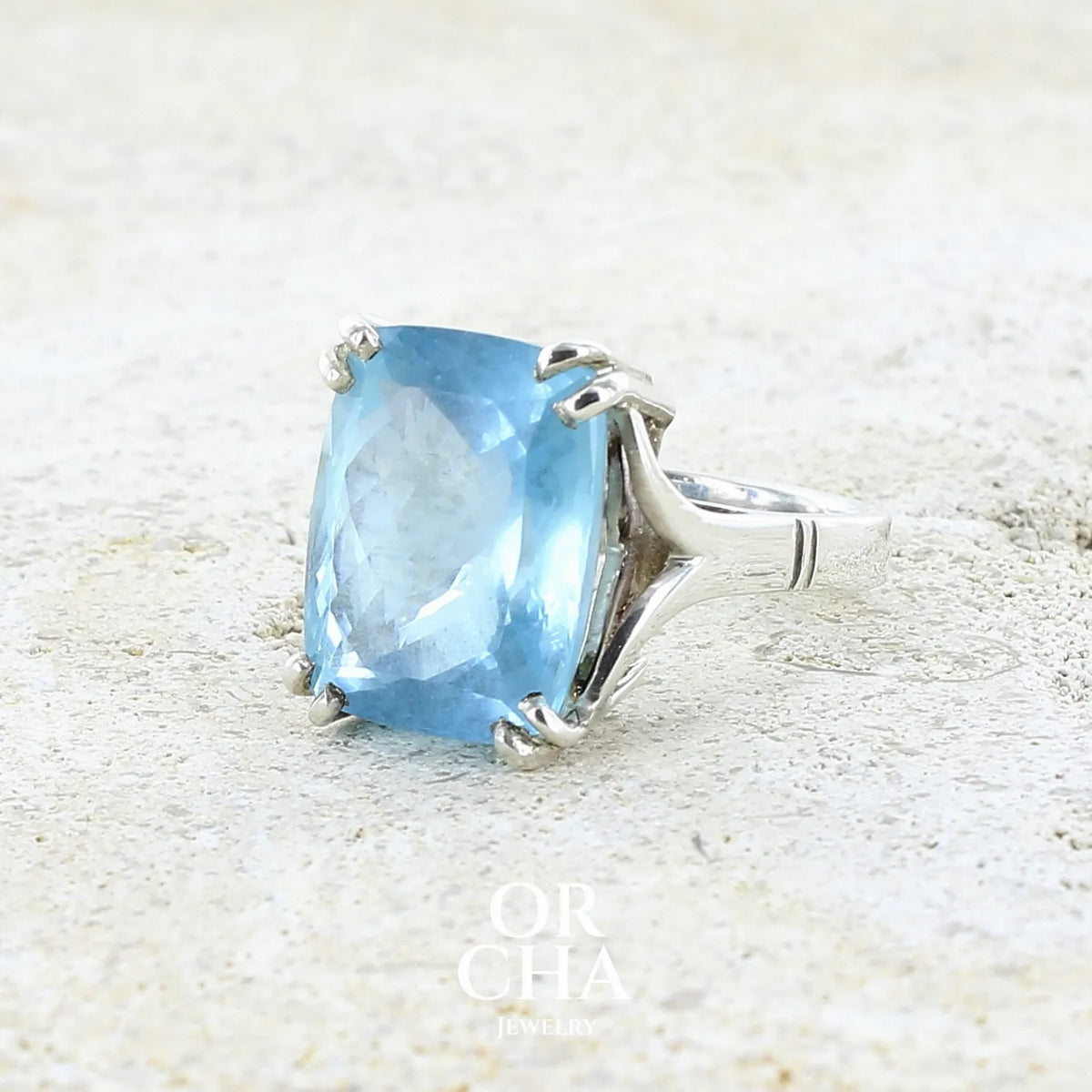 profil bague pour femme en argent massif sertie d'une magnifique aigue marine taillée de 10,3 carats de couleur bleue clair intense. Pierre transparente lumineuse comportant de légères inclusions. Bijou unique réalisée en taille 54 par Orchajewelry