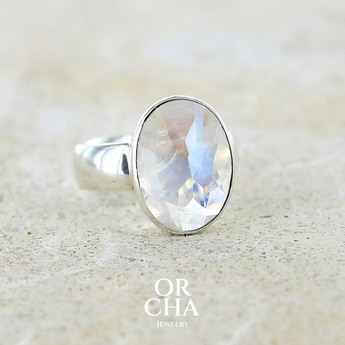 Profil droit d'un bague cocktail pour femme en argent massif 925 sertie d'une Labradorite blanche taillée de 6,7 carats incolore aux reflets bleutés et arc en ciel. Pierre transparente avec inclusions. Bijoux unique réalisée en taille 57 par Orchajewelry