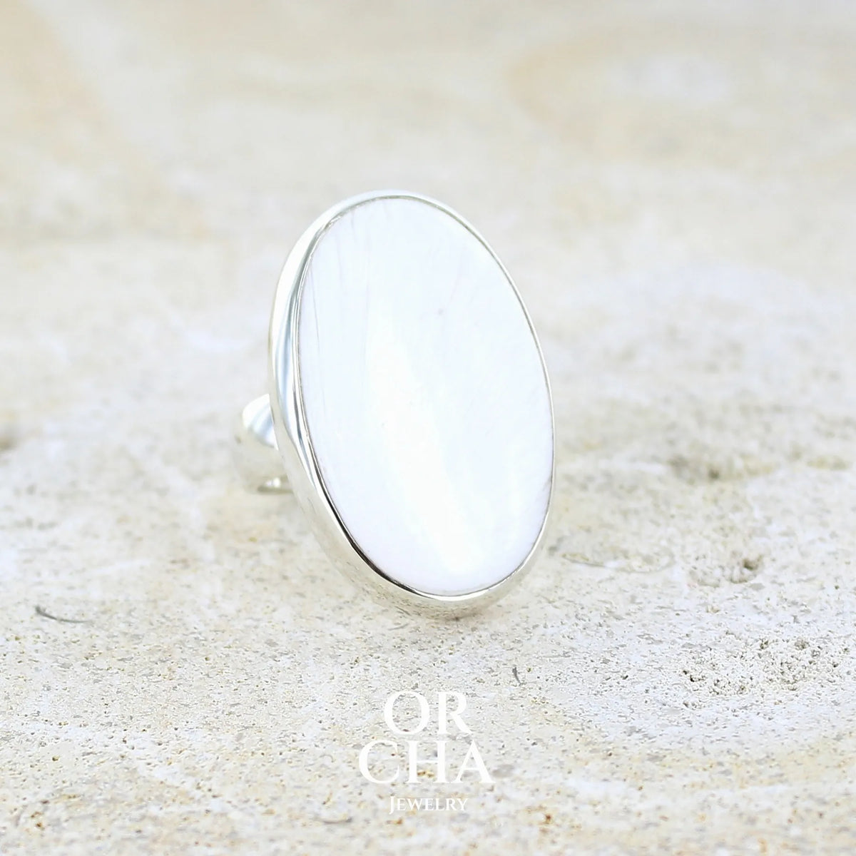profil droit d'une bague pour femme en argent massif sertie d'un cabochon de scolecite de couleur blanc pur. Pierre naturelle de qualité opaque taillée en ovale. Bague unique réalisée en taille 58 par Orcha jewelry
