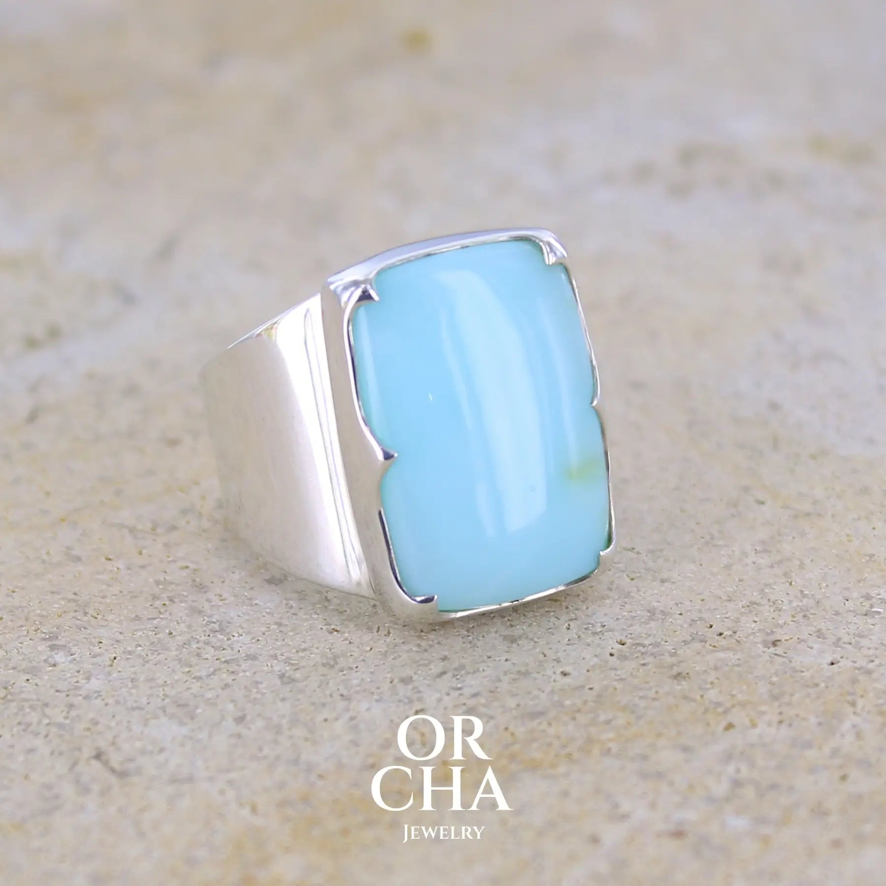 profil droit d'une bague pour femme en argent massif sculptées d'étoiles et autres corps célestes sertie d'une Opale bleue du Pérou. Pierre cabochon en forme de rectangle, pierre naturelle de couleur bleu ciel ciel, bleu turquoise. Pierre naturelle de qualité opaque. Taille 58. Bijoux unique, éthique et durable présenté dans un coffret de notre marque, prêt à offrir. Livraison offerte, certificat d'authenticité, service client.