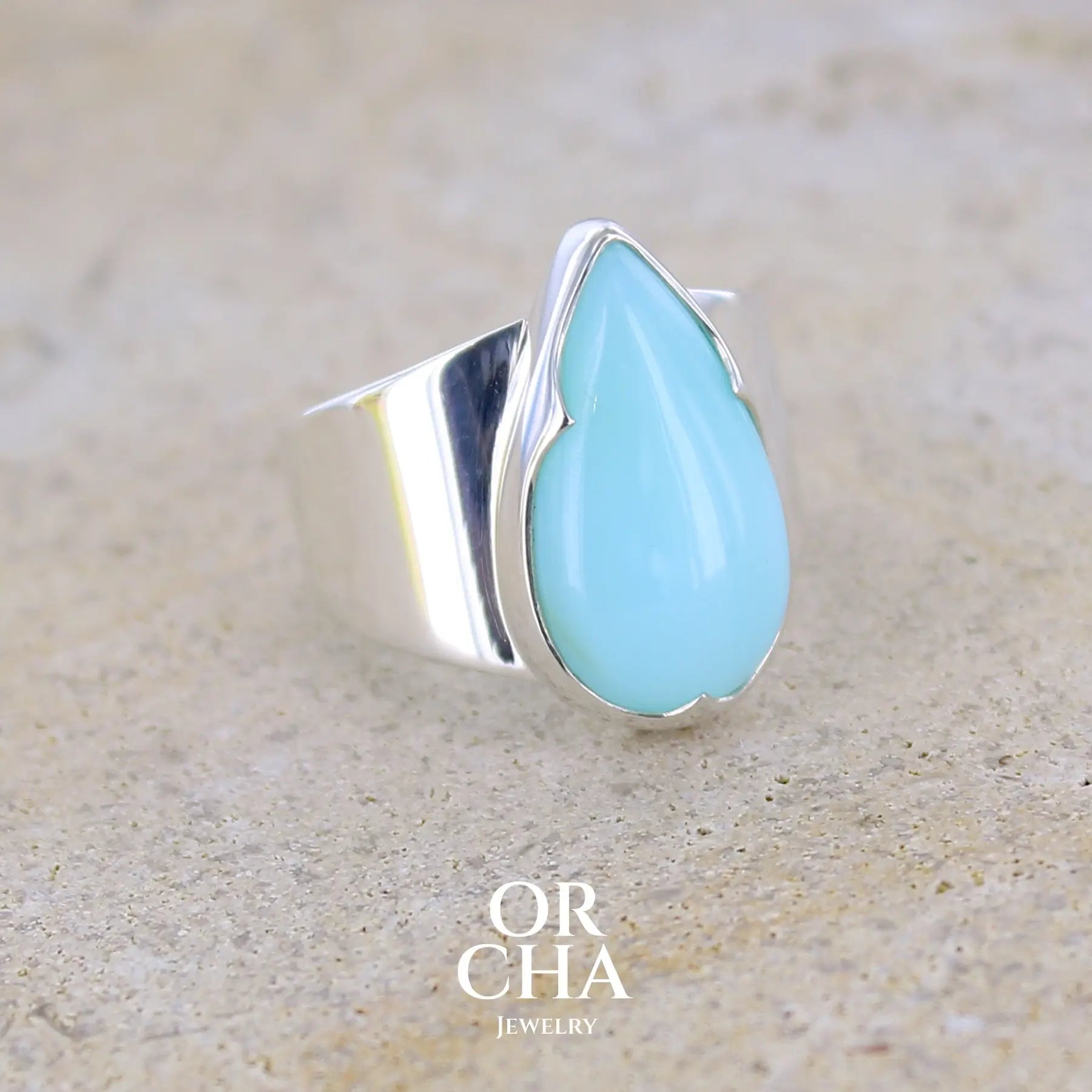 profil droit d'une bague pour femme en argent massif, sertie d'un cabochon d'opale bleue du Pérou. Pierre taillée en forme de longue goutte. Pierre opaque. Taille 54. Bijoux unique, éthique et durable présenté dans un coffret de notre marque, prêt à offrir. Livraison offerte, certificat d'authenticité, service client.