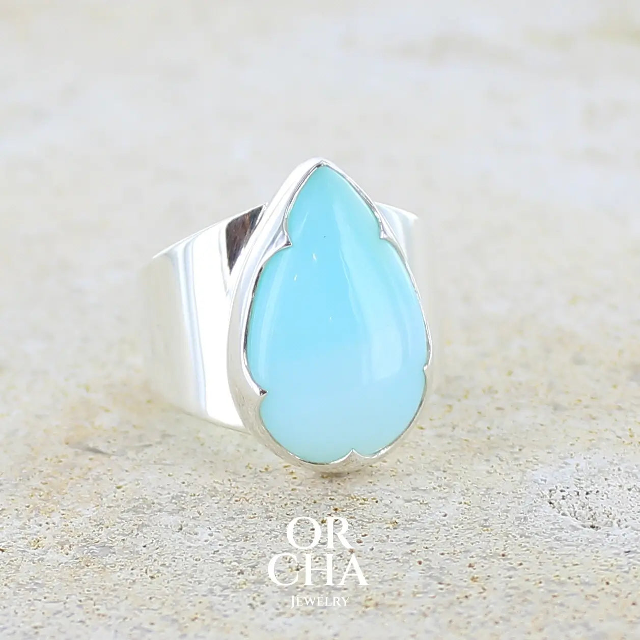 profil droit d'une bague pour femme en argent massif, sertie d'un cabochon d'opale bleue du Pérou de couleur bleu ciel. Pierre taillée en forme de goutte de qualité opaque. Bijou unique réalisé en taille 58.