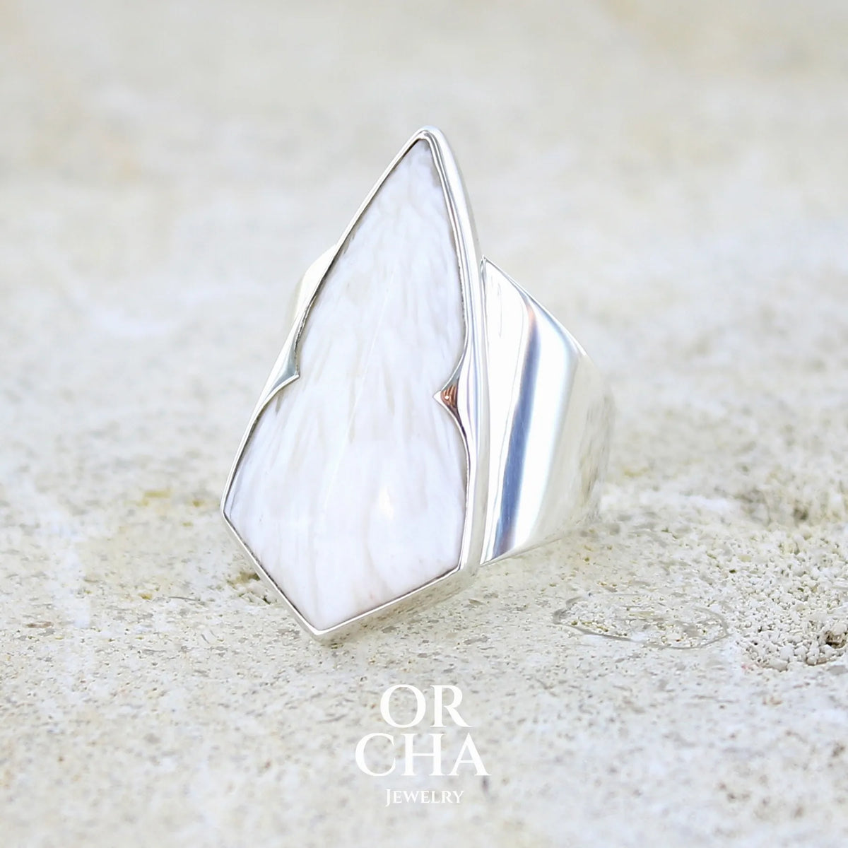profil gauche d'une bague contemporaine pour femme en argent massif sertie d'une scolecite blanche. Pierre naturelle de qualité opaque taillée en forme de losange. Bague unique réalisée en taille 56 par Orcha jewelry