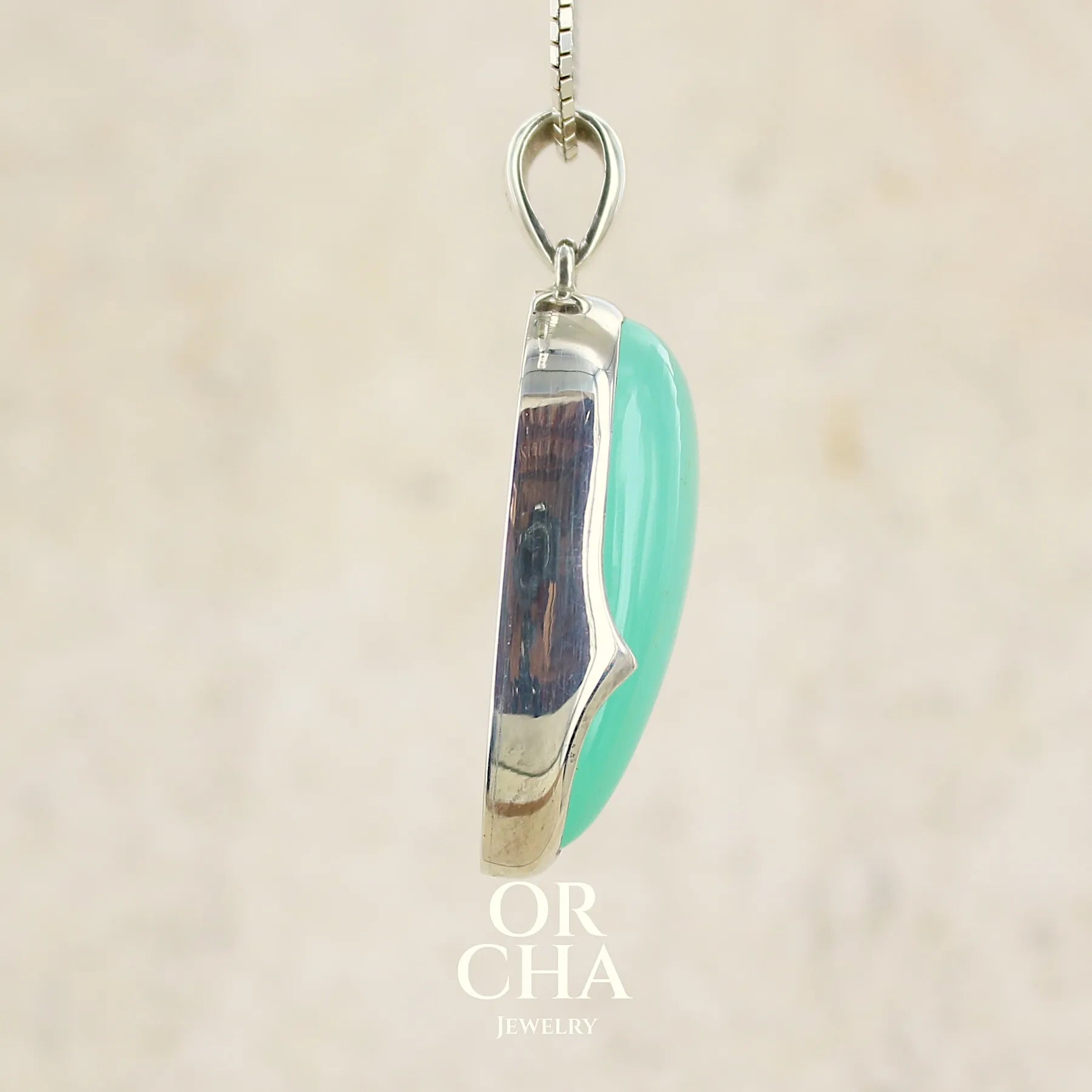 profil d'un pendentif pour femme en argent massif, sertie d'un cabochon de chrysoprase de couleur vert bleuté. Pierre de qualité translucide taillée en forme de goutte. Bijoux unique par Orcha jewelry