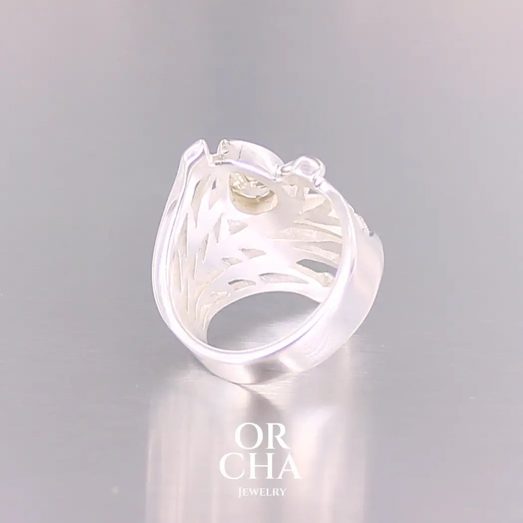 Vue arrière d'une grande Bague topaze impériale et argent massif illustrant un feuillage tropicale. Bijou pour femme sertie d'une Topaze impériale de couleur jaune pâle doré, pierre  facettée en forme de poire. Pierre très lumineuse et propre à l'oeil. Bijoux unique, éthique et durable présenté dans un coffret de notre marque, prêt à offrir. Livraison offerte, certificat d'authenticité, service client.