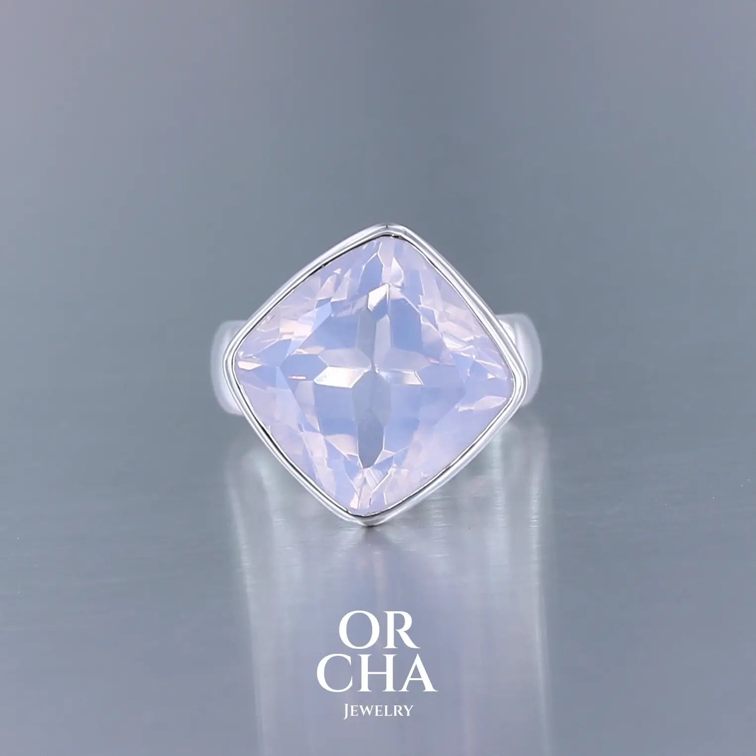 Bague cocktail pour femme en argent massif sertie d'un Quartz lavande. Pierre facettée de forme carrée de qualité transparente, propre à l'oeil. Pierre naturelle de couleur violette pastel teintée de rose avec de légers reflets opalescents. Plusieurs tailles disponibles. Bijoux unique, éthique et durable présenté dans un coffret de notre marque, prêt à offrir. Livraison offerte, certificat d'authenticité, service client.
