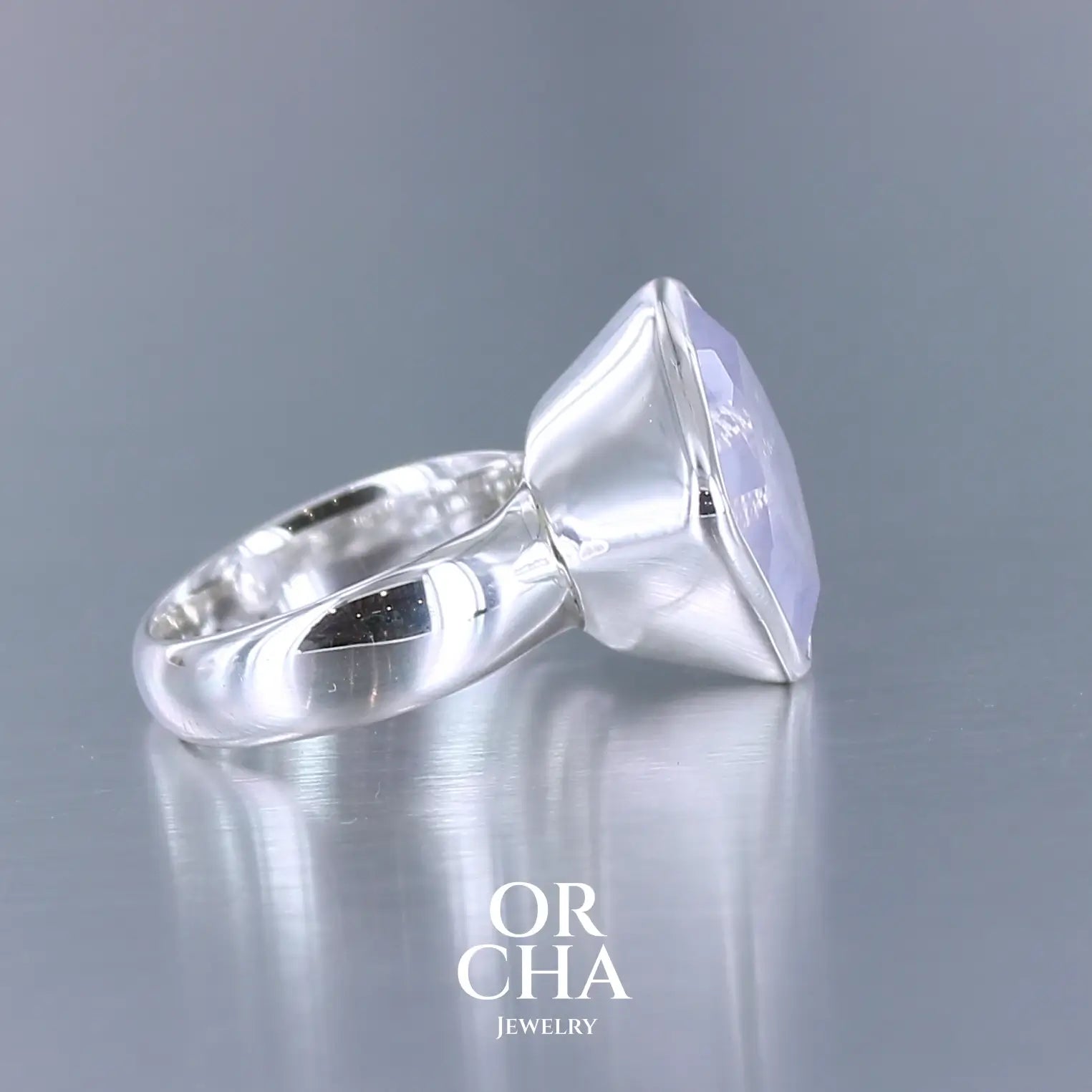 Bague cocktail pour femme en argent massif sertie d'un Quartz lavande. Pierre facettée de forme carrée de qualité transparente, propre à l'oeil. Pierre naturelle de couleur violette pastel teintée de rose avec de légers reflets opalescents. Plusieurs tailles disponibles. Bijoux unique, éthique et durable présenté dans un coffret de notre marque, prêt à offrir. Livraison offerte, certificat d'authenticité, service client.