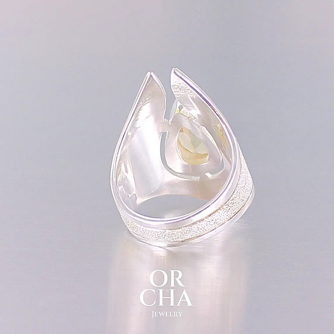 détail de dos d'une Grande bague contemporaine pour femme en argent massif sertie d'une Citrine. Pierre facettée en forme de goutte de qualité transparente, propre à l'oeil. Pierre naturelle de couleur jaune or lumineux. Bijoux unique, éthique et durable présenté dans un coffret de notre marque, prêt à offrir. Livraison offerte, certificat d'authenticité, service client.