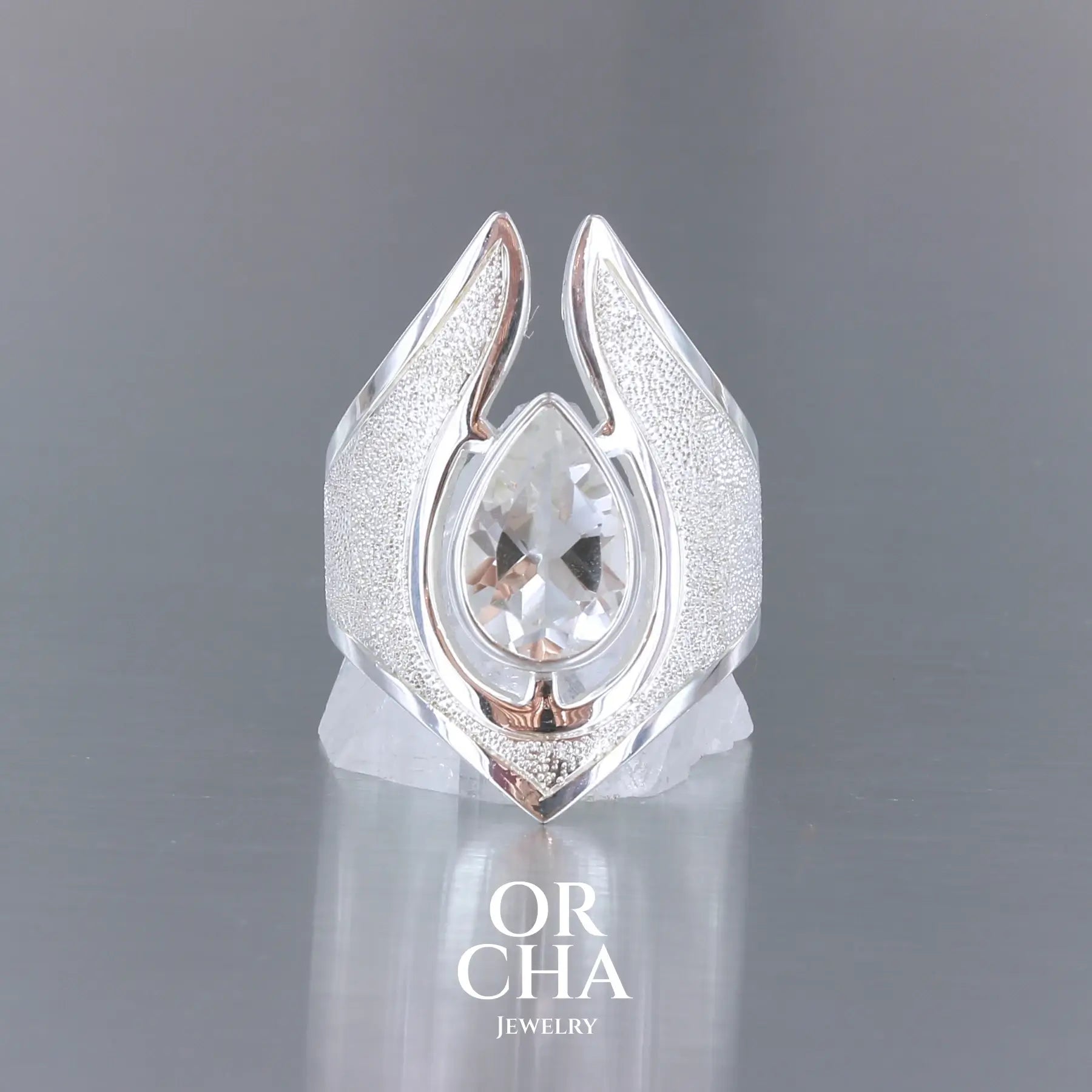 Grande bague pour femme en argent massif sertie d'une Topaze blanche, collection Bastet. Pierre facettée en forme de goutte, pierre naturelle incolore avec un très bel éclat. Pierre fine de qualité transparente propre à l'oeil. Disponible en plusieurs tailles. Bijoux unique, éthique et durable présenté dans un coffret de notre marque, prêt à offrir. Livraison offerte, certificat d'authenticité, service client.
