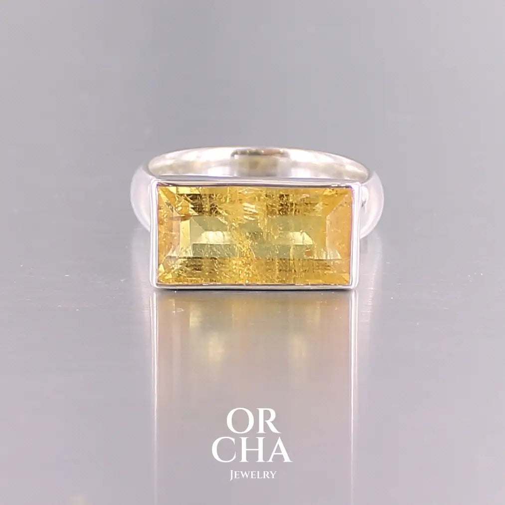 Bague cocktail pour femme en argent massif sertie d'une Héliodore. Pierre facettée de forme rectangulaire de qualité transparente avec inclusions naturelles. Pierre de couleur jaune soleil intense. Bague réalisée en taille 60.5. Bijoux unique, éthique et durable présenté dans un coffret de notre marque, prêt à offrir. Livraison offerte, certificat d'authenticité, service client.