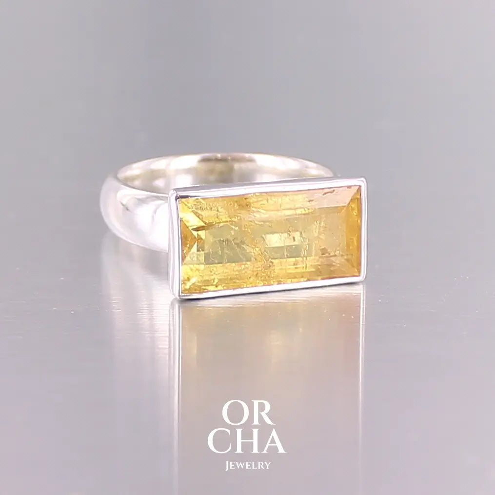 Bague cocktail pour femme en argent massif sertie d'une Héliodore. Pierre facettée de forme rectangulaire de qualité transparente avec inclusions naturelles. Pierre de couleur jaune soleil intense. Bague réalisée en taille 60.5. Bijoux unique, éthique et durable présenté dans un coffret de notre marque, prêt à offrir. Livraison offerte, certificat d'authenticité, service client.