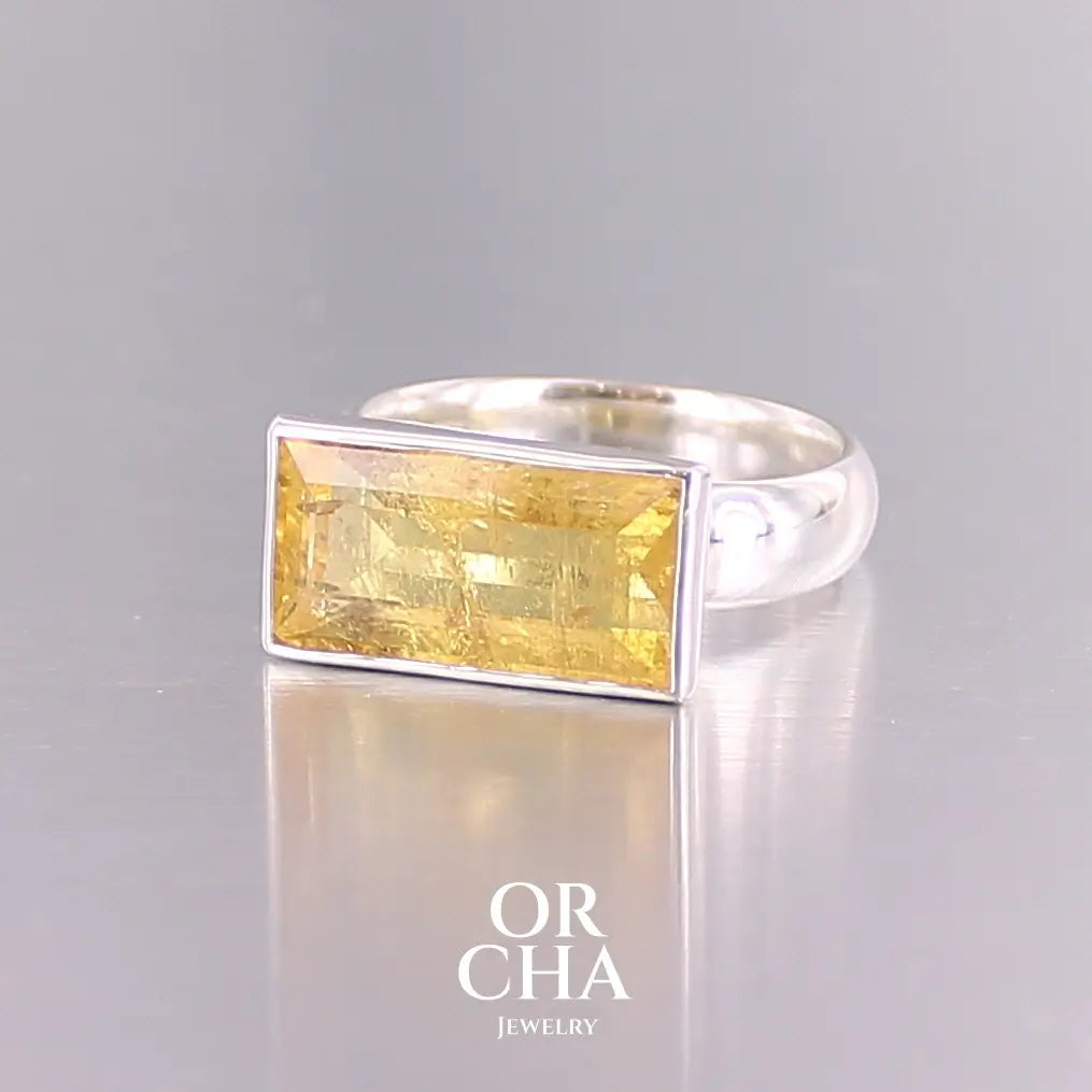 Bague cocktail pour femme en argent massif sertie d'une Héliodore. Pierre facettée de forme rectangulaire de qualité transparente avec inclusions naturelles. Pierre de couleur jaune soleil intense. Bague réalisée en taille 60.5. Bijoux unique, éthique et durable présenté dans un coffret de notre marque, prêt à offrir. Livraison offerte, certificat d'authenticité, service client.