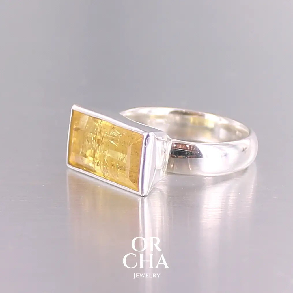 Bague cocktail pour femme en argent massif sertie d'une Héliodore. Pierre facettée de forme rectangulaire de qualité transparente avec inclusions naturelles. Pierre de couleur jaune soleil intense. Bague réalisée en taille 60.5. Bijoux unique, éthique et durable présenté dans un coffret de notre marque, prêt à offrir. Livraison offerte, certificat d'authenticité, service client.