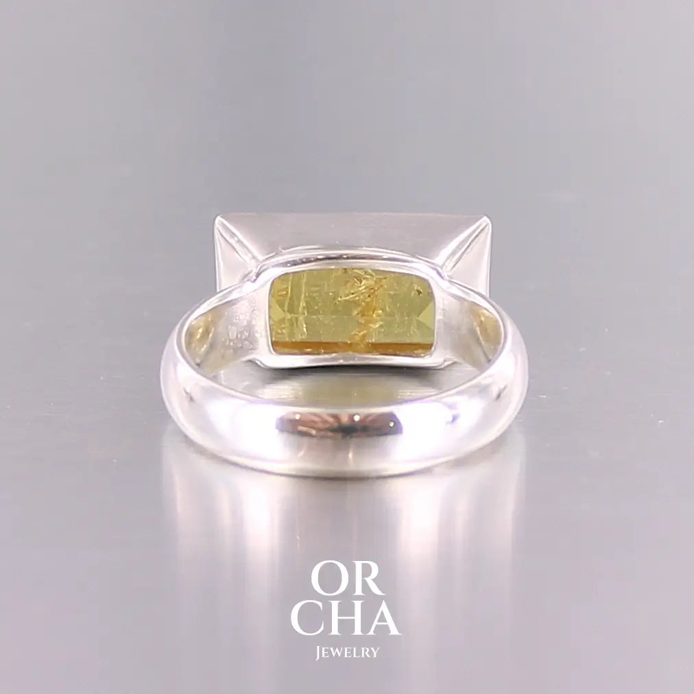 Bague cocktail pour femme en argent massif sertie d'une Héliodore. Pierre facettée de forme rectangulaire de qualité transparente avec inclusions naturelles. Pierre de couleur jaune soleil intense. Bague réalisée en taille 60.5. Bijoux unique, éthique et durable présenté dans un coffret de notre marque, prêt à offrir. Livraison offerte, certificat d'authenticité, service client.