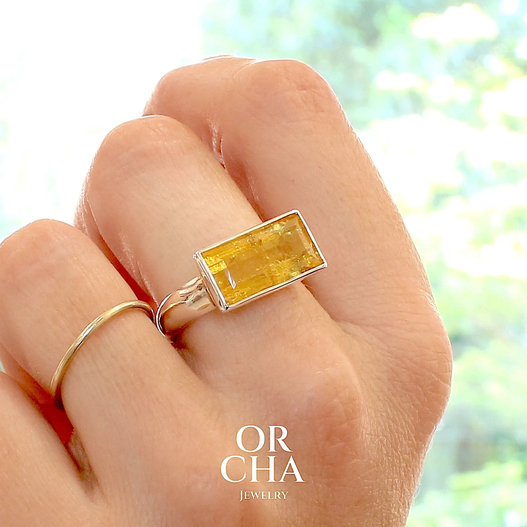 Bague cocktail pour femme en argent massif sertie d'une Héliodore. Pierre facettée de forme rectangulaire de qualité transparente avec inclusions naturelles. Pierre de couleur jaune soleil intense. Bague réalisée en taille 60.5. Bijoux unique, éthique et durable présenté dans un coffret de notre marque, prêt à offrir. Livraison offerte, certificat d'authenticité, service client.