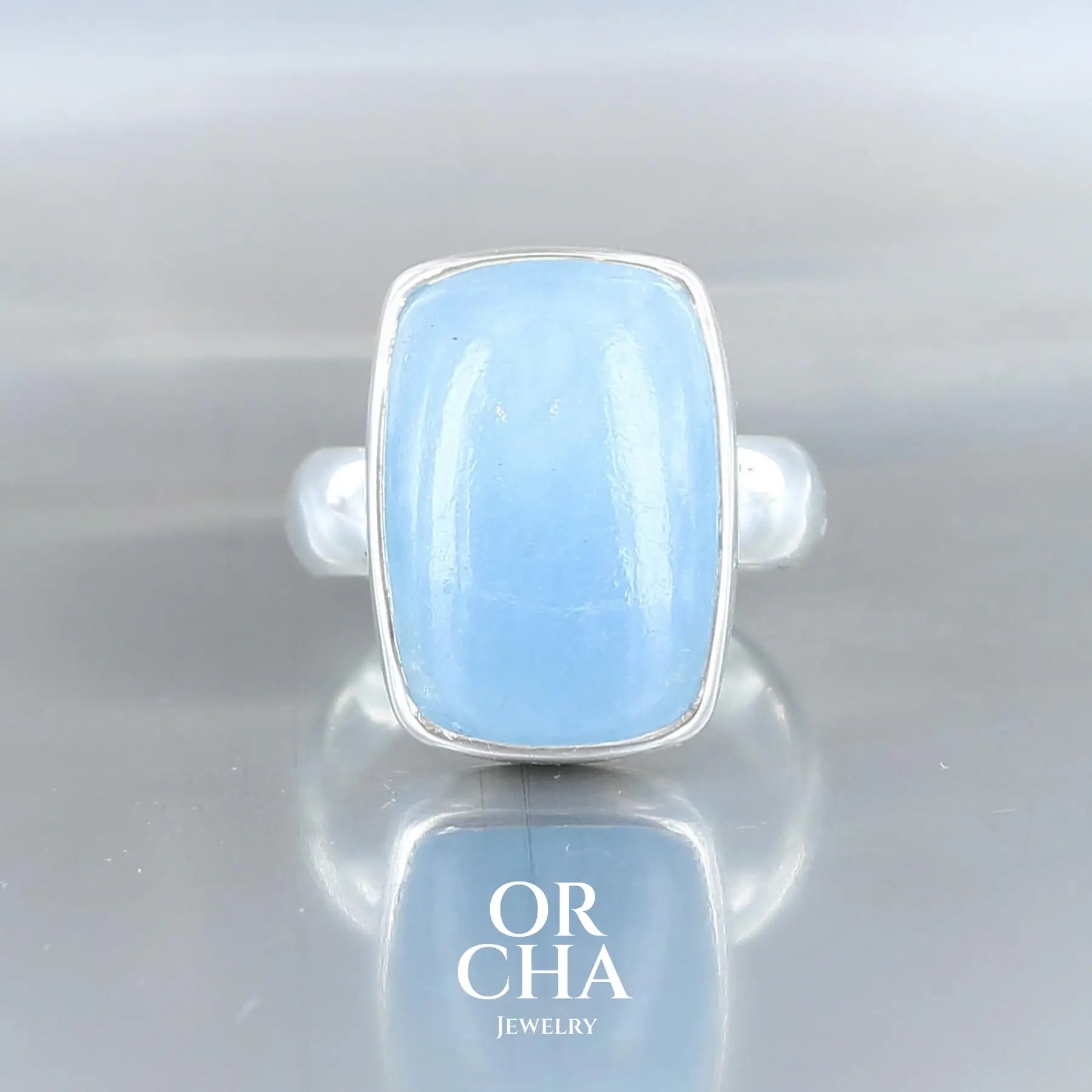 Bague pour femme en argent massif 925, sertie d’un cabochon de forme rectangulaire d'Aigue-marine, pierre naturelle de couleur bleu. Cette bague est une pièce unique, fabriquée entièrement à la main, en taille 54. Bijou unique, éthique et durable présenté dans un coffret de notre marque, prêt à offrir.