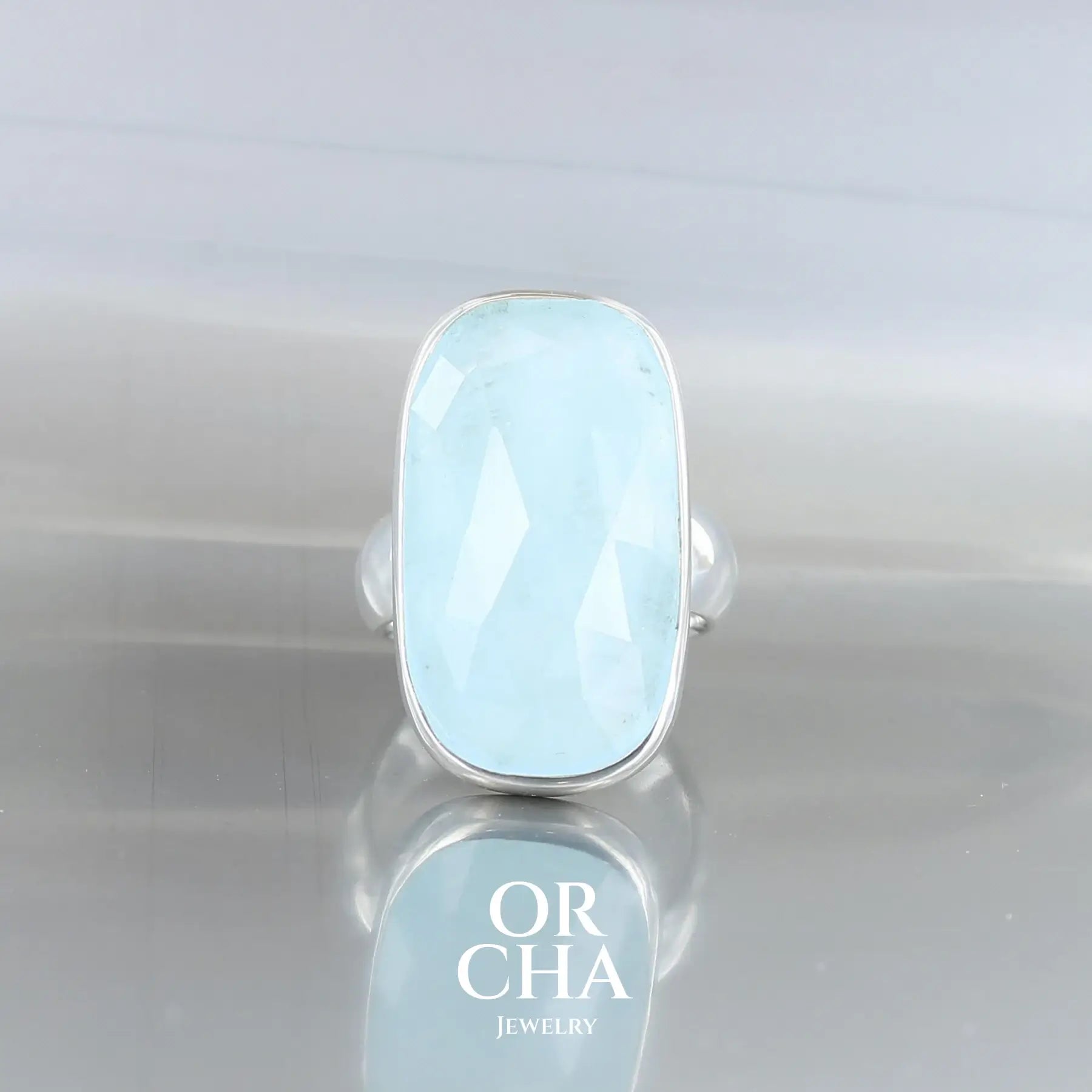 Bague rectangulaire en argent massif sertie d’une Aigue-marine, pierre naturelle de couleur bleue glacé. Cette bague est une pièce unique, fabriquée à la main, en taille 54. Bijou éthique et durable présenté dans un coffret de notre marque, prêt à offrir.