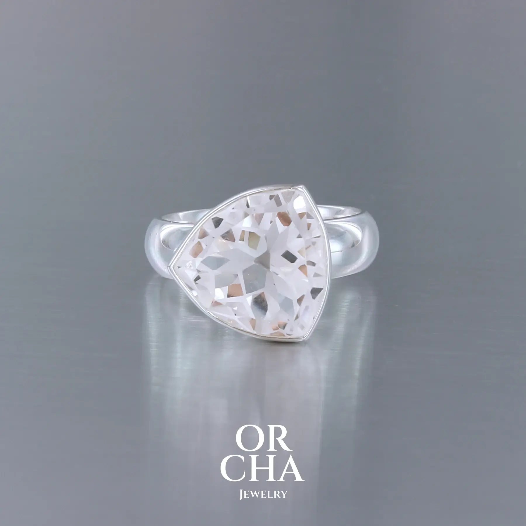 Bague cocktail pour femme en argent massif sertie d'un Cristal de roche gravé d'une fleur de vie. Pierre facettée de forme carrée de qualité transparente, propre à l'oeil. Pierre naturelle incolore et blanche sur les parties gravées. Bague disponible en différentes tailles. Bijoux unique, éthique et durable présenté dans un coffret de notre marque, prêt à offrir. Livraison offerte, certificat d'authenticité, service client.