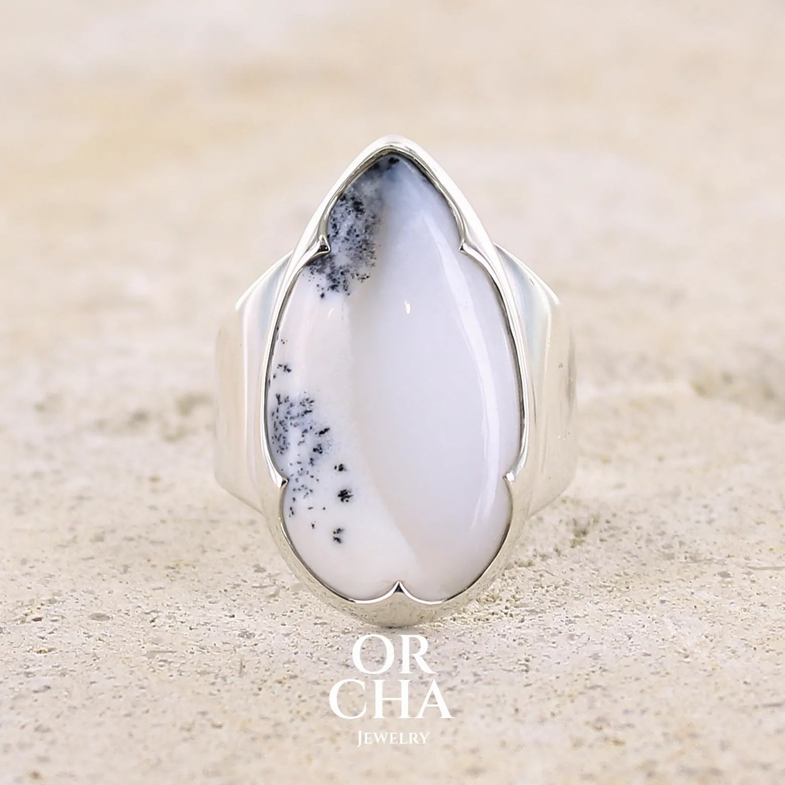 Bague pour femme en argent massif sertie d'un cabochon d'agate dendritique de couleur blanche et noire. Pierre translucide à inclusions paysages de manganèse contrastées. Bijou unique réalisée en taille 58 par Orcha Jewelry