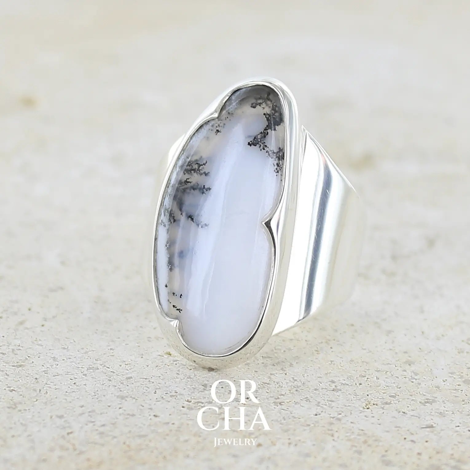 Bague pour femme en argent massif sertie d'un cabochon d'agate dendritique de couleur blanc pur et noir. Pierre opaque translucide à inclusions arborescentes de dendrites de manganèse noires contrastées. Bijou unique réalisée en taille 58 par Orchajewelry