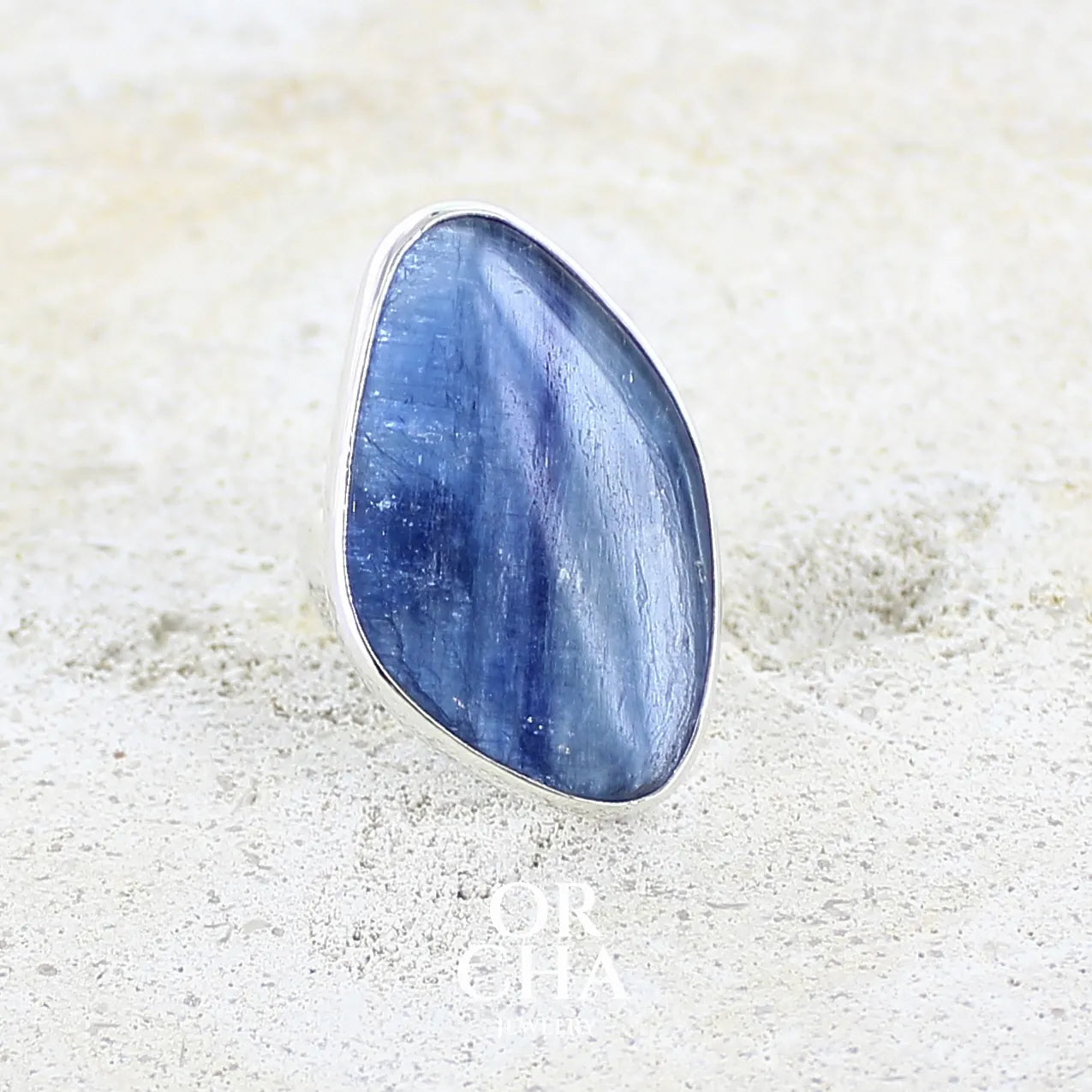 Profil droit d'une bague pour femme en argent massif sertie d'un cabochon de cyanite de couleur bleu jean nacré. Pierre translucide à inclusions. Bijou unique réalisée en taille 54 par Orchajewelry