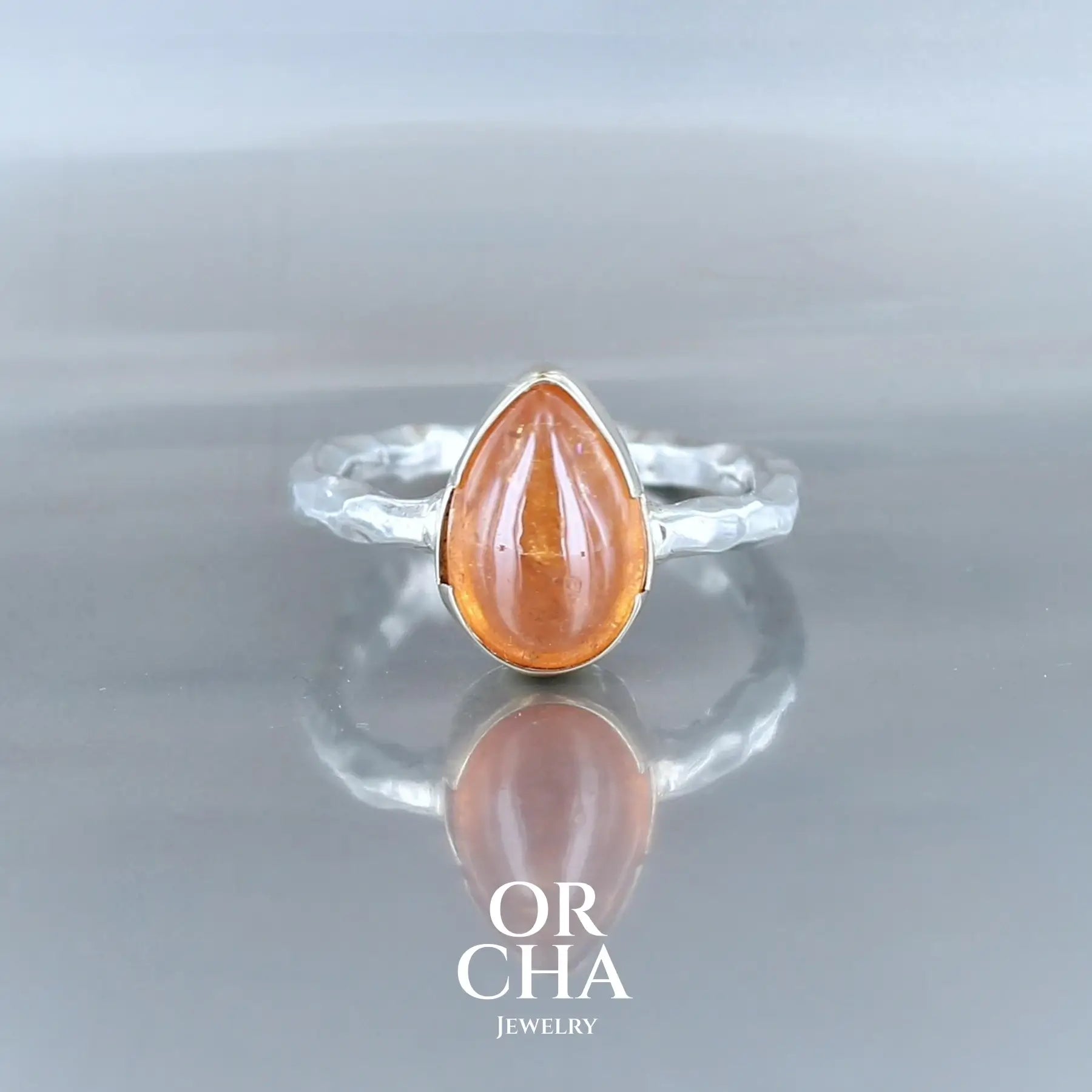 Bague solitaire pour femme en argent massif et or 12K sertie d'un Grenat spessartite à la couleur orange soutenu aussi nommé couleur Fanta. Pierre cabochon naturelle translucide présentant des inclusions. Taille 50. Bijoux unique, éthique et durable présenté dans un coffret de notre marque, prêt à offrir. Livraison offerte, certificat d'authenticité, service client.