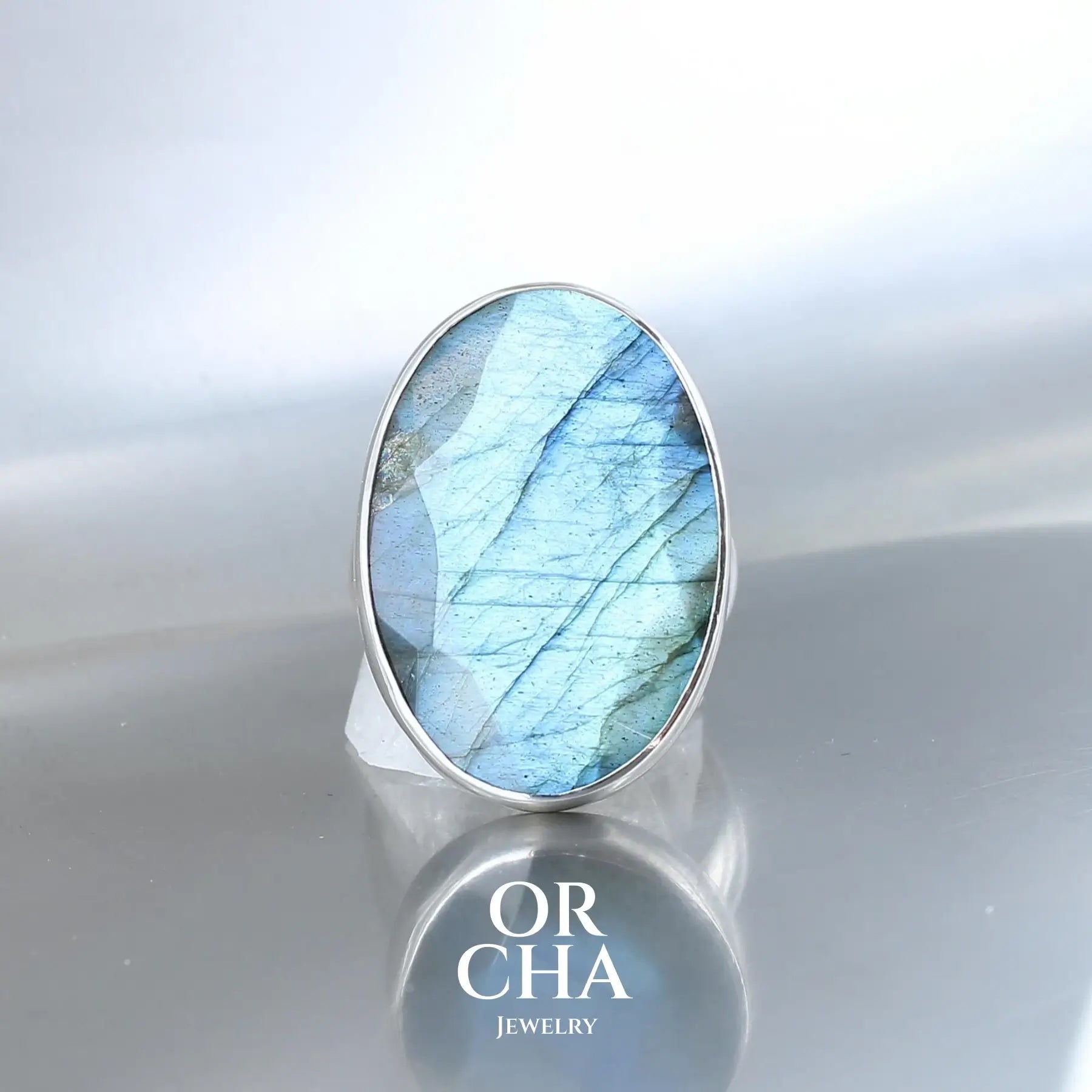 Bague pour femme en argent massif serti d'une Labradorite pierre aux reflets bleus selon la lumière et l angle de vision. Pierre facettée naturelle translucide présentant des inclusions fréquents sur ce type de pierre. Taille 60. Bijoux unique, éthique et durable présenté dans un coffret de notre marque, prêt à offrir. Livraison offerte, certificat d'authenticité, service client.