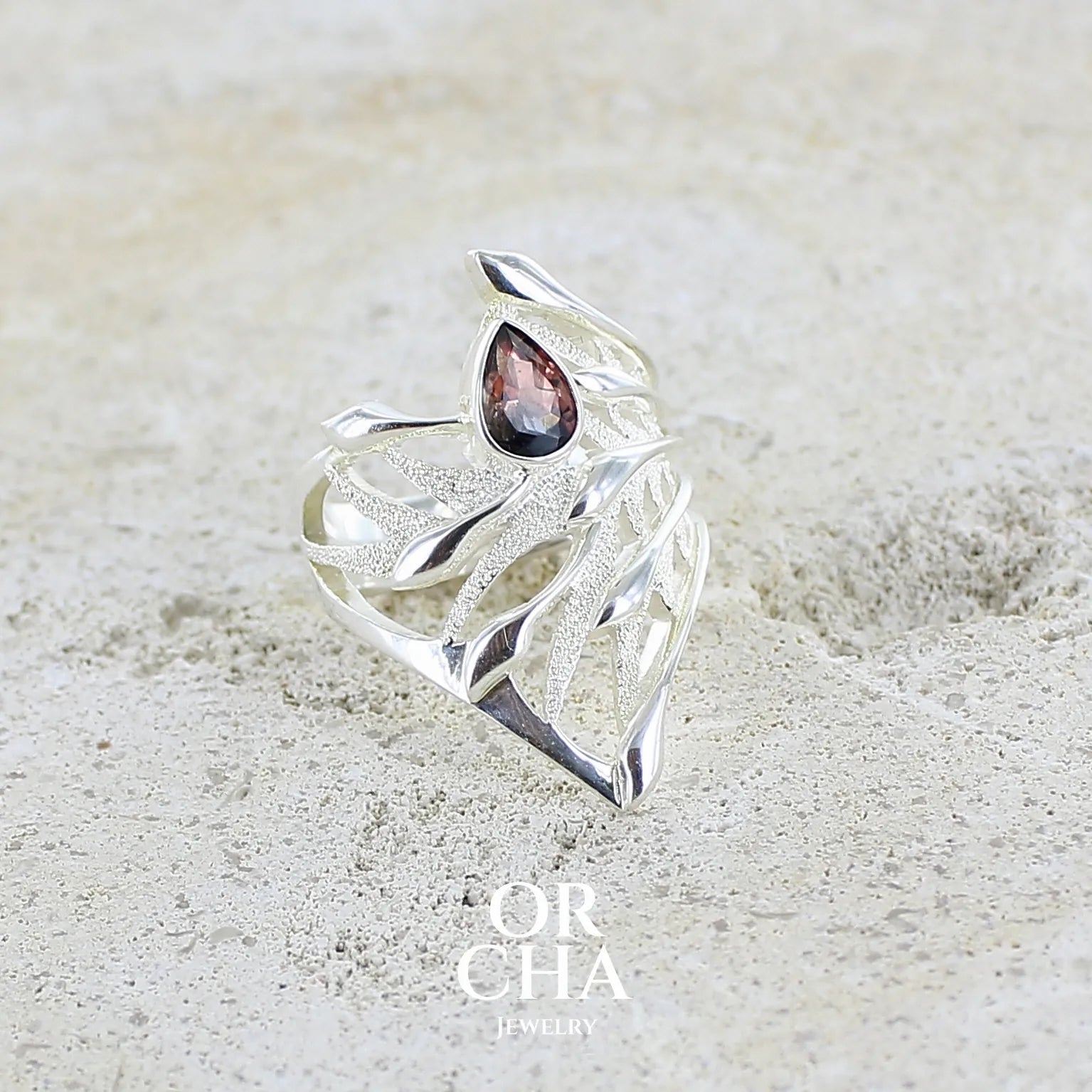 profil d'une Grande Bague pour femme en argent massif, sertie d'une Tourmaline bicolore rose pêche et bleue nuit. Pierre facettée en forme de goutte. Pierre incolore, très lumineuse et propre à l'oeil. Bijoux unique au design de feuillage tropicale travaillé en filigrane réalisé en taille 54.