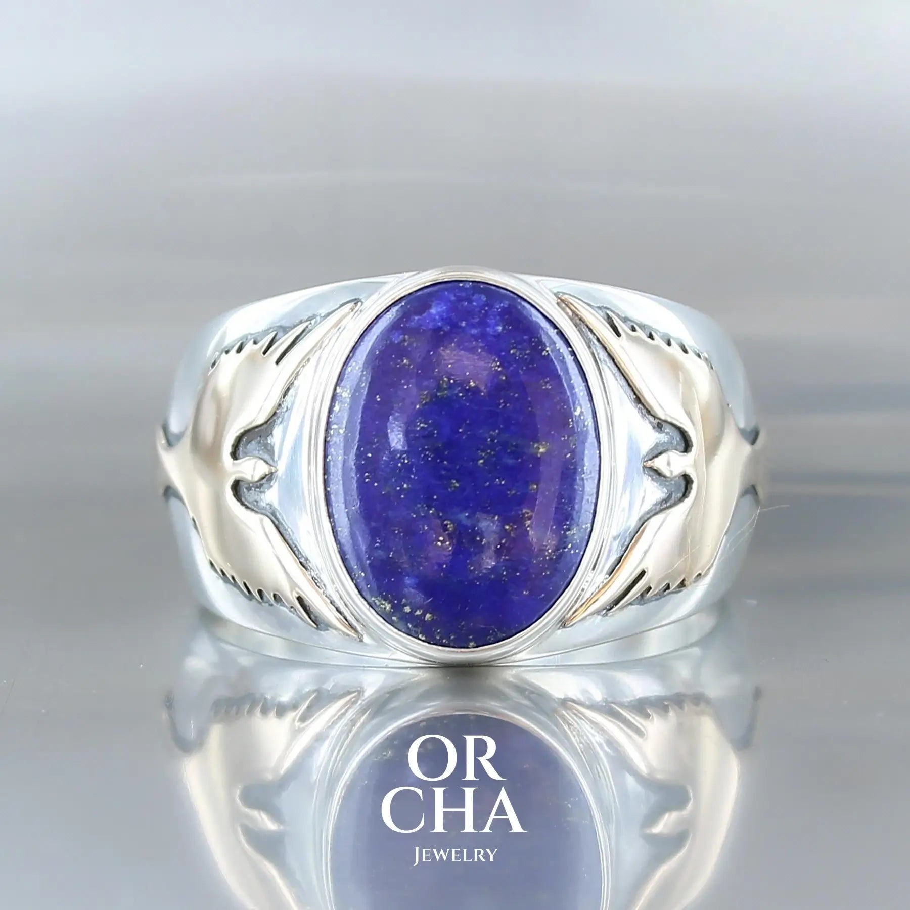 Bague pour homme en argent massif et or 9k où s'illustrent de chaque cotés de la bague des carpes Koï en or. Cette bague est sertie d'un cabochon de Lapis Lazuli de couleur bleu nuit mouchetée de pyrite dorées. Pierre  naturelle opaque. Taille 70. Bijoux unique, éthique et durable présenté dans un coffret de notre marque, prêt à offrir. Livraison offerte, certificat d'authenticité, service client.