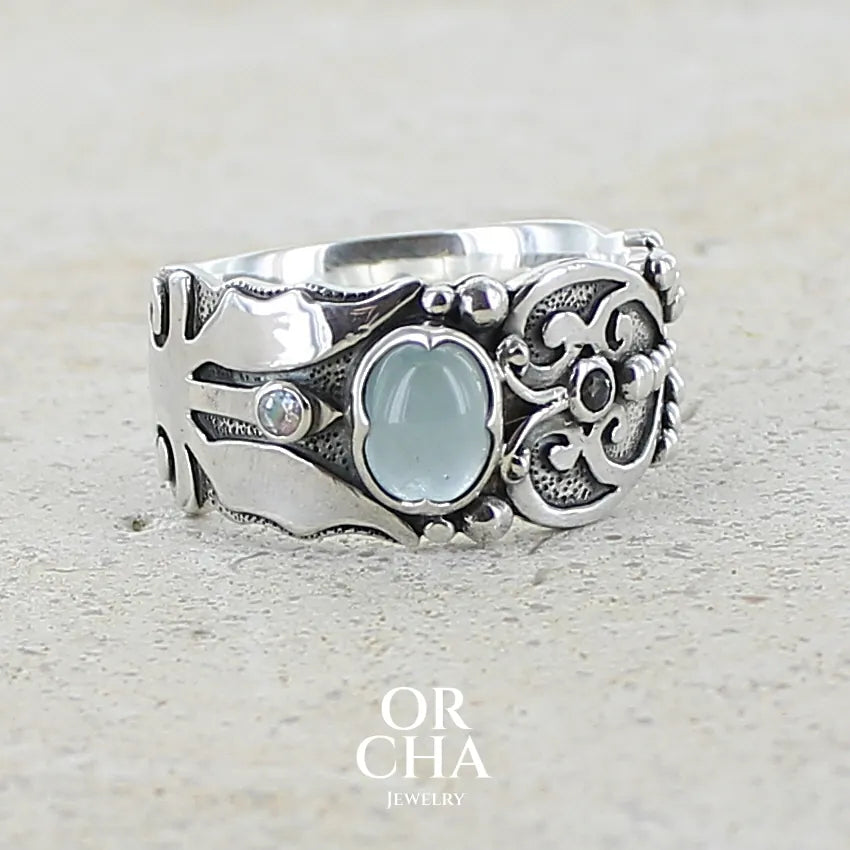 Bague anneau pour homme en argent massif d'inspiration celtique, médiévale. Bague sertie d'un cabochon d'aigue-marine de couleur bleu gris. Pierre  translucide propre à l'oeil. Bijou unique réalisé en taille 58. 
