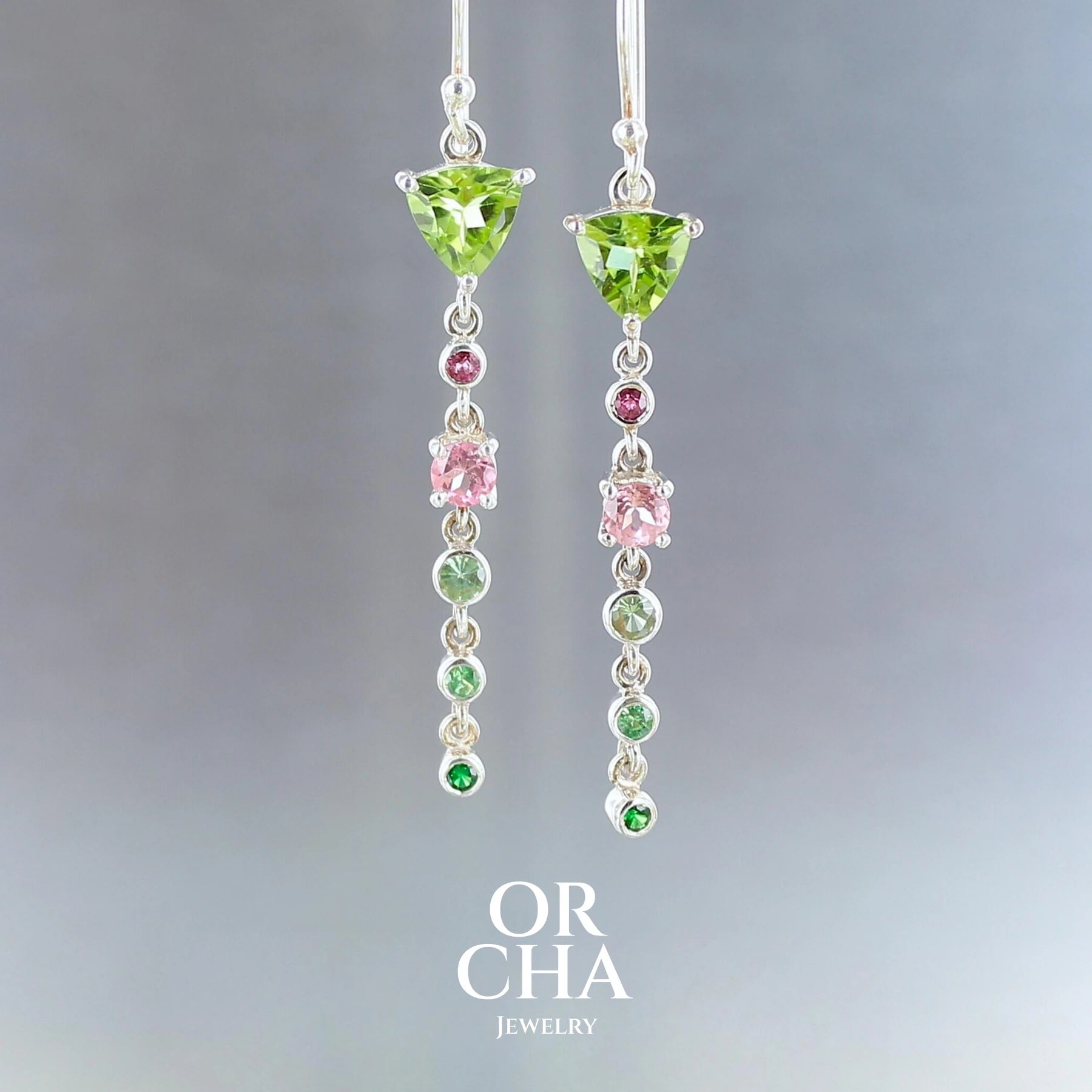 Boucles d'oreilles pendantes, pour femme, réalisées en argent sterling 925, ornées de Péridots, de Tourmalines roses et vertes et de Grenats Tsavorites, un total de 12 pierres semi précieuses naturelles. Monture de qualité à la fois solide et délicate, travaillée de manière traditionnelle