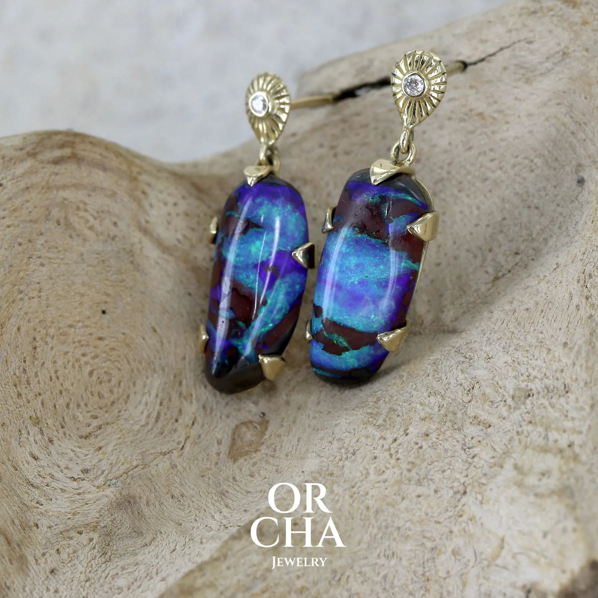 Boucles d'oreilles pendantes en or 18k serties d'opales aux feux multicolores turquoises et bleus violets, ainsi que de diamants. Pierres cabochons de qualité opaque. Bijoux uniques par Orchajewelry.